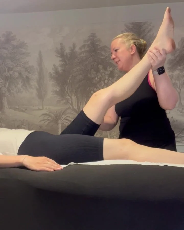 A therapist assessing range of motion in a client's leg