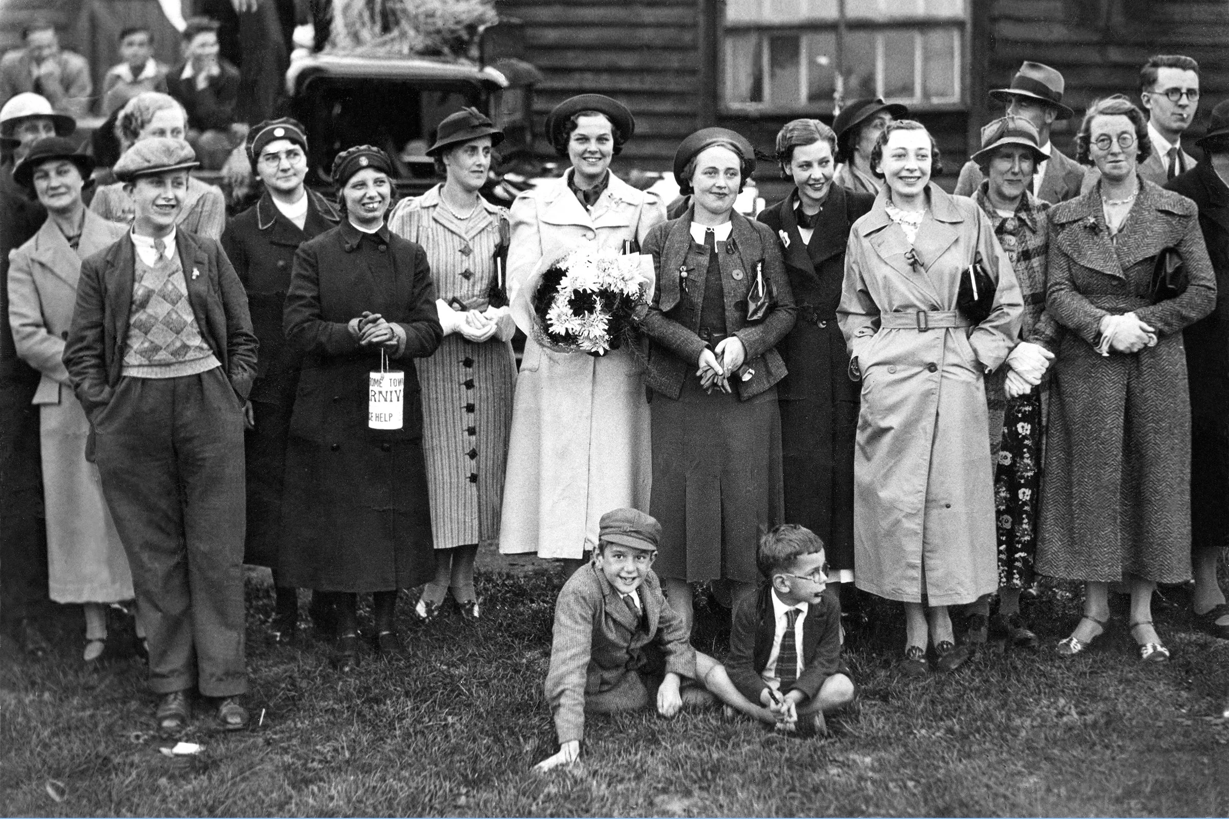 A wonderful photo of  MOLLY   (holding flowers) at a Carnival event outside the Red Triangle Hut in the Mary Baily playing field 1937