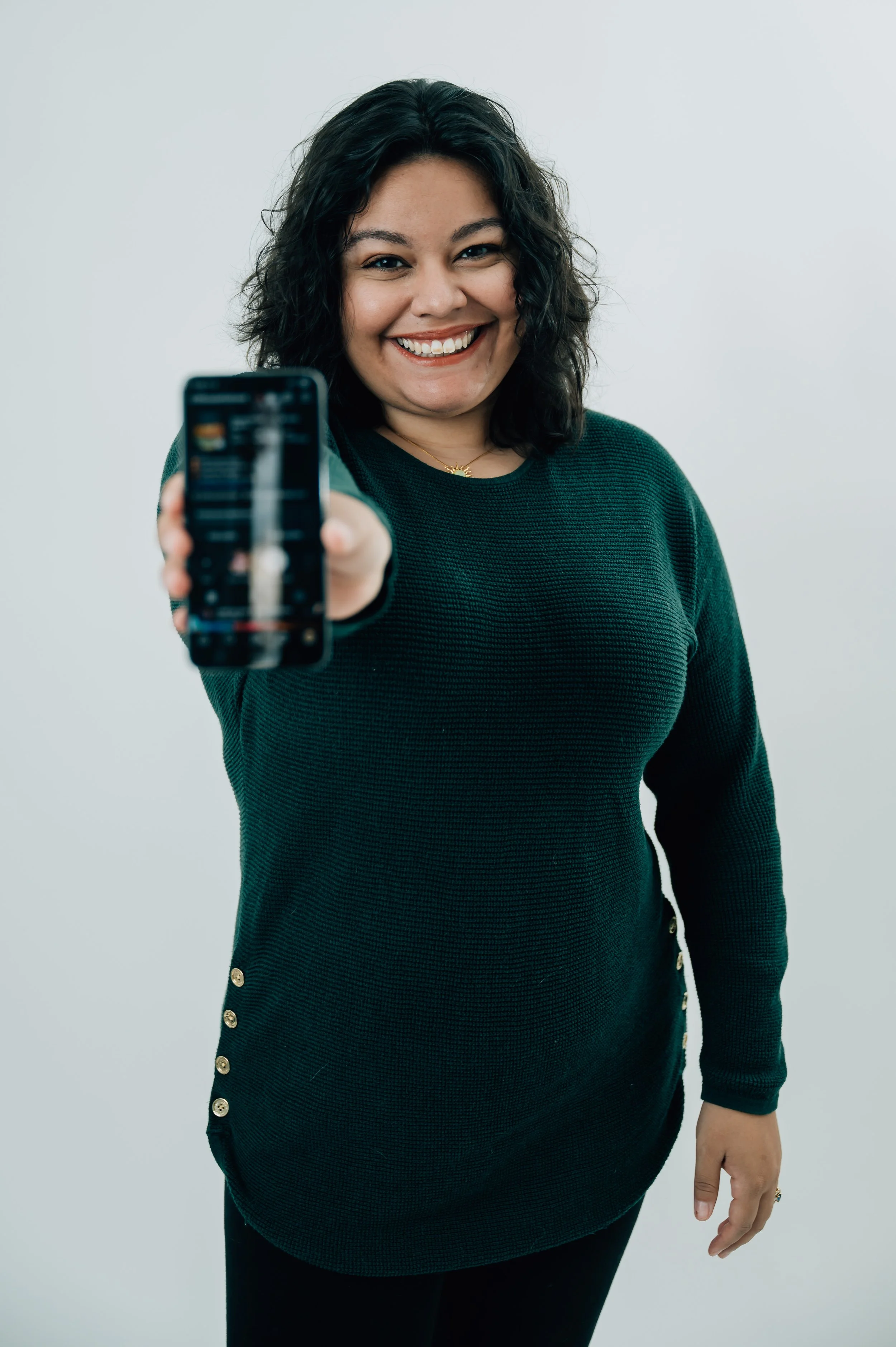 Gabby Camacho, operations specialist, showing phone with a client's social media page that she manages