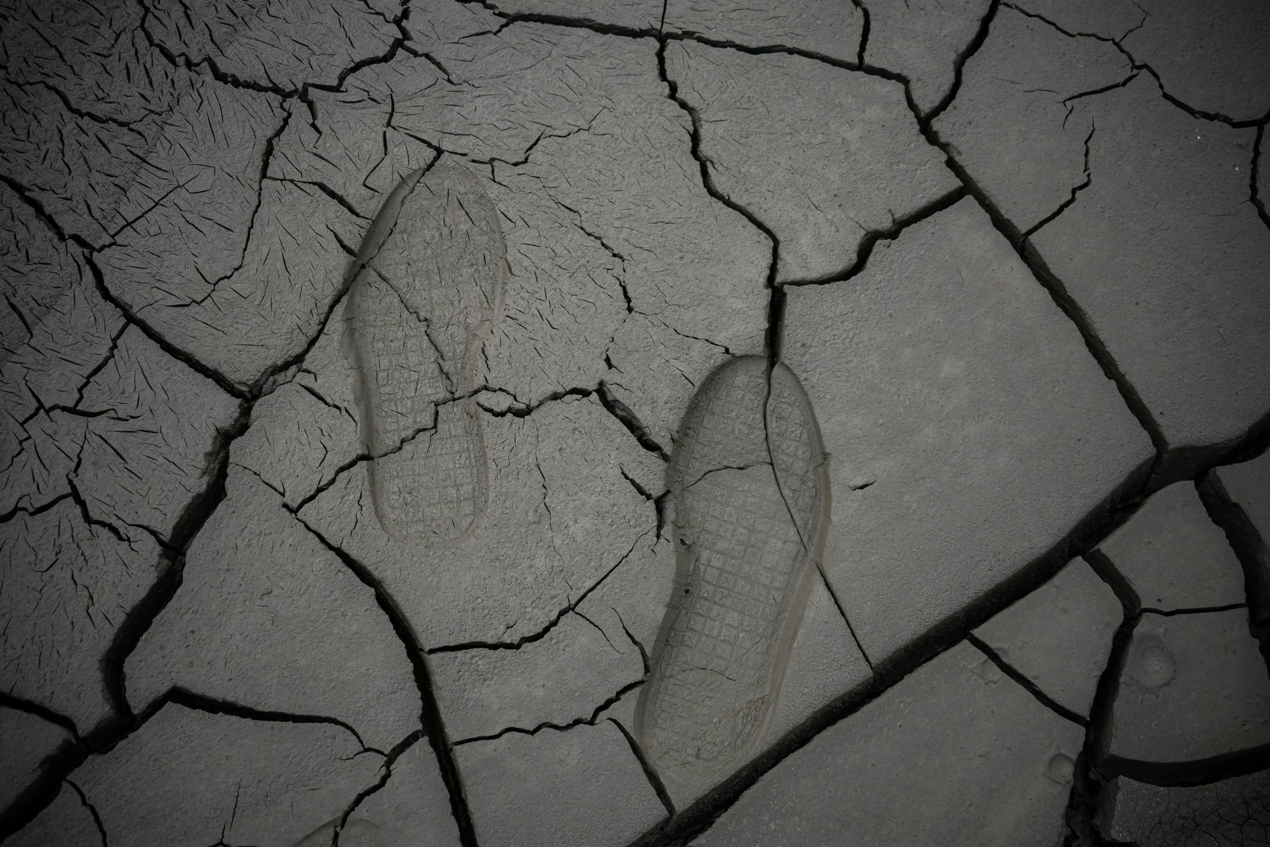image of cracked stone with two footprints embedded