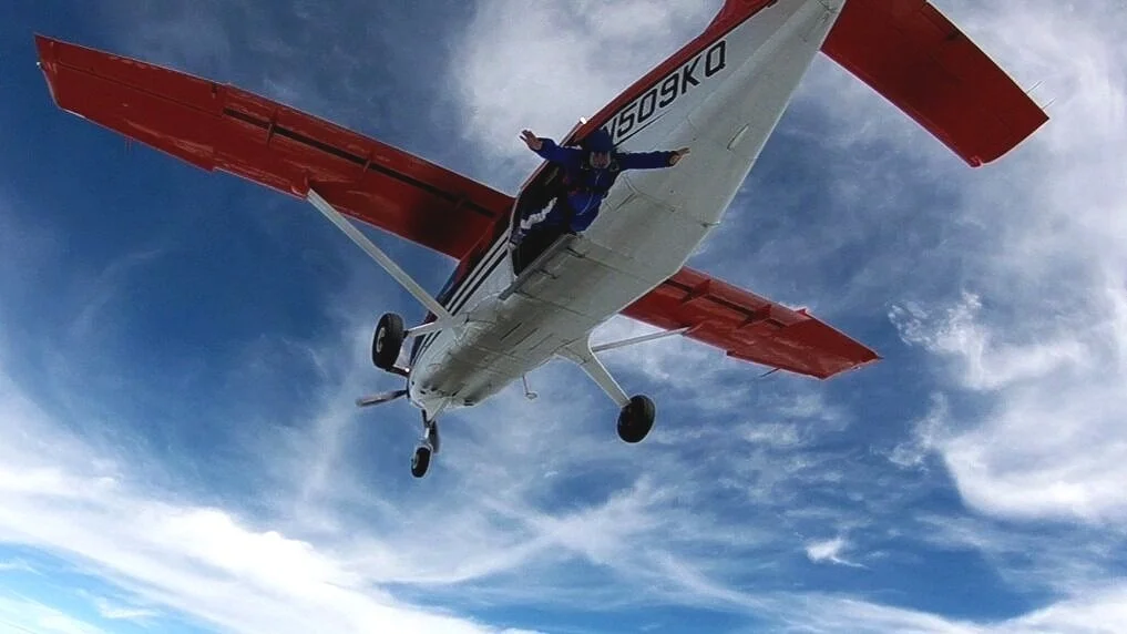 Skydiver diving out toward another skydiver