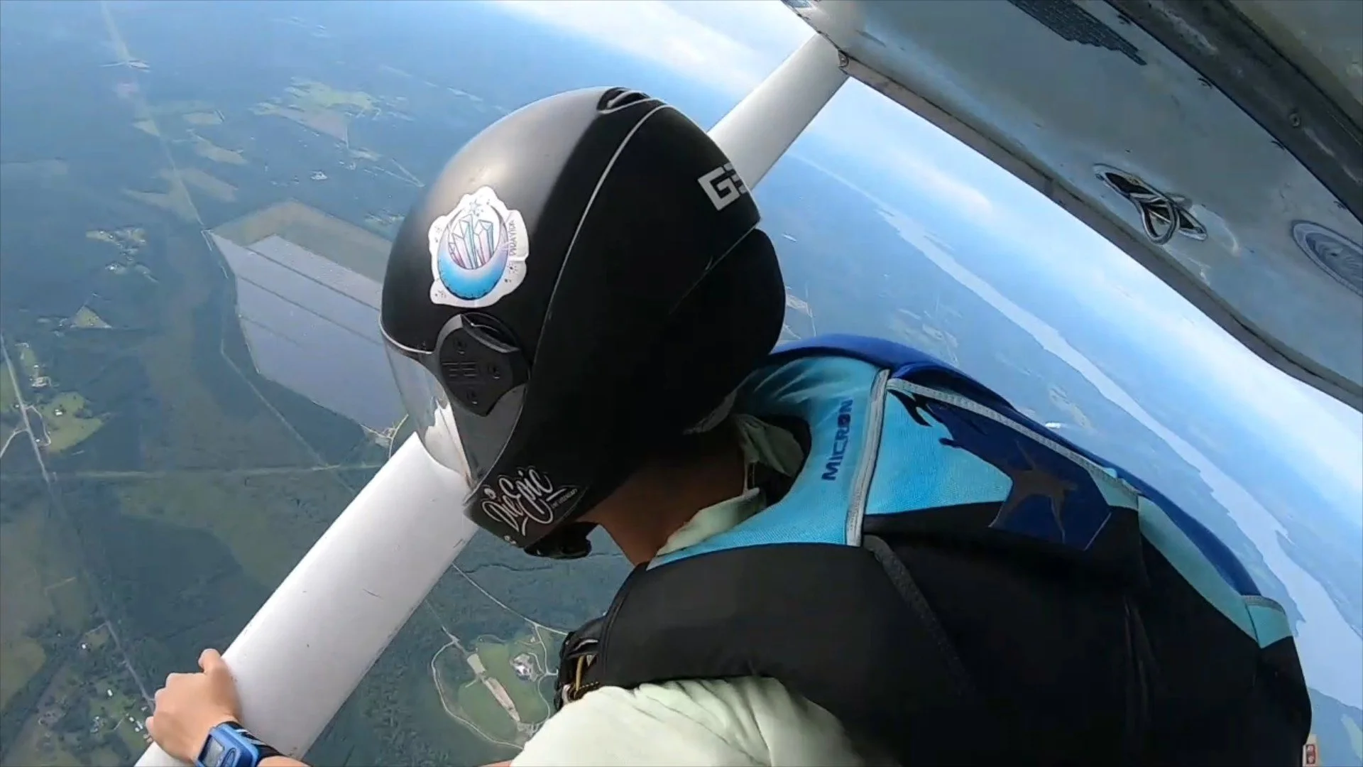 Skydiver in aircraft door at altitude preparing for exit - the moment of mental rehearsal before a jump