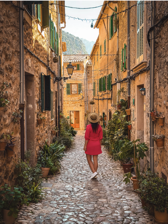 alldemossa or Deià with honey-colored stone buildings, mountains, greenery, and a little village life.