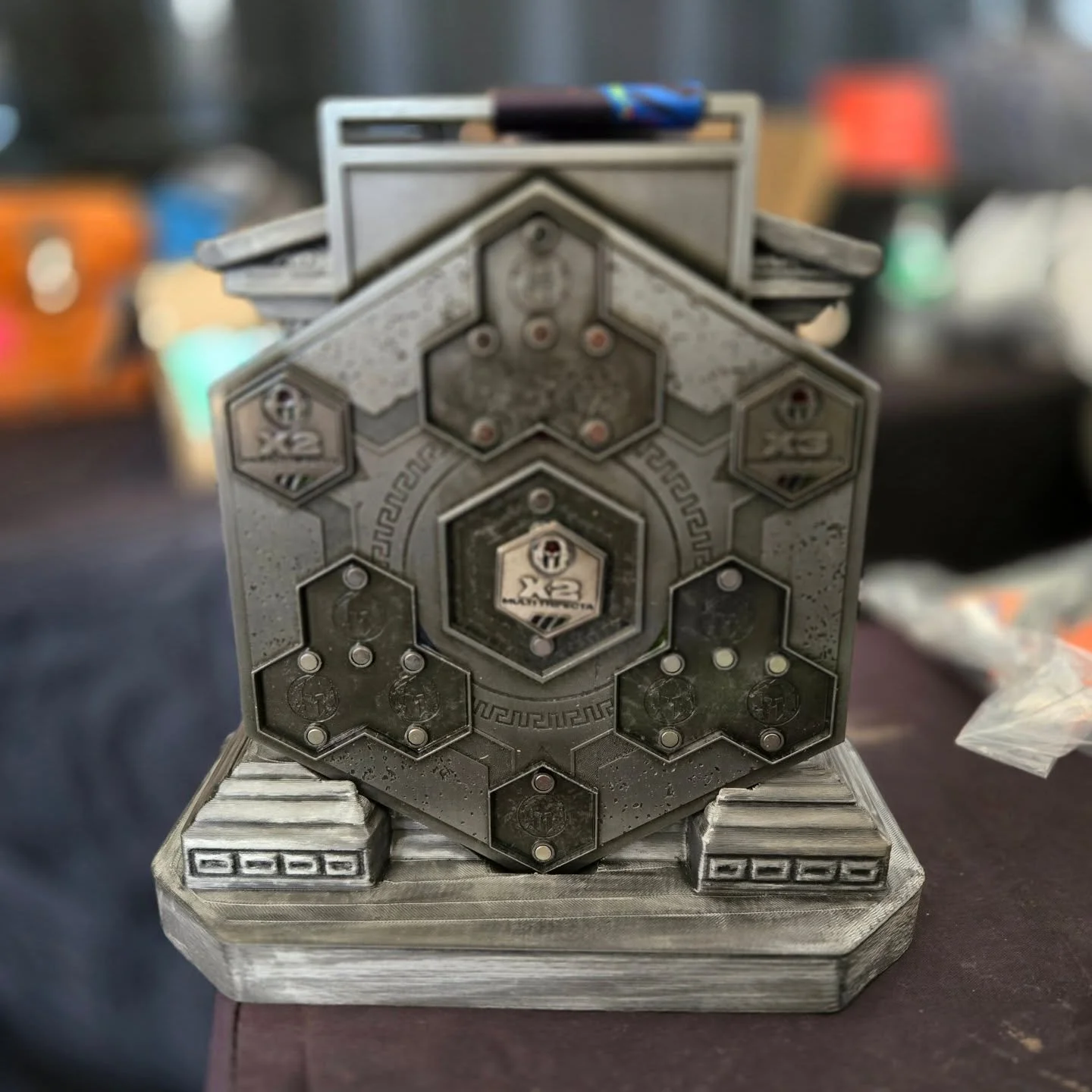 Greek column Trifecta Hex Stand (fits 7in trifecta X2 through X5 medal). The smaller stand fits the individual race medals and the initial 2026 Trifecta X1. Link in bio.