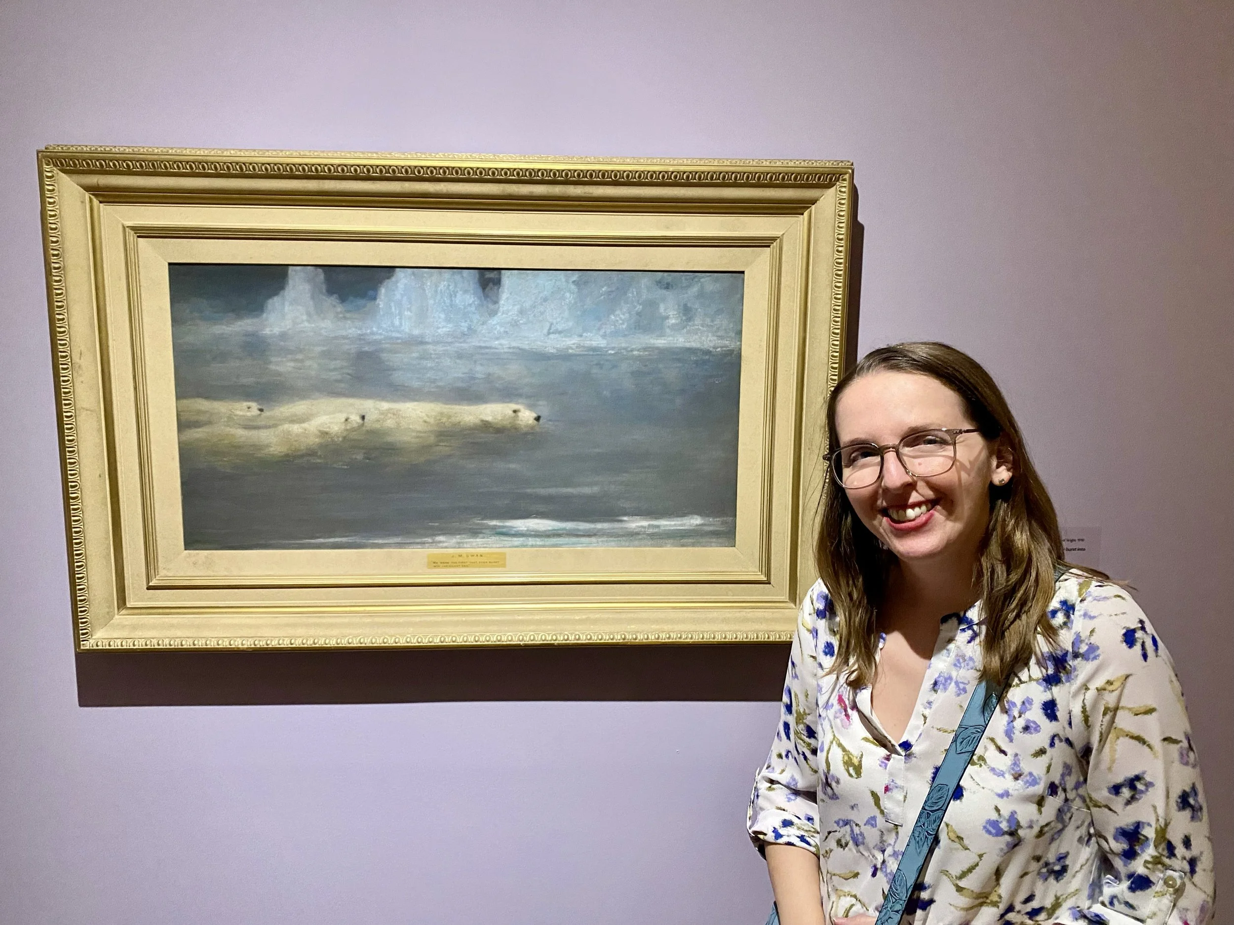 Posing with John Macallan Swan's painting "We were the first that ever bust into the silent sea" of a mother polar bear swimming with 2 cubs