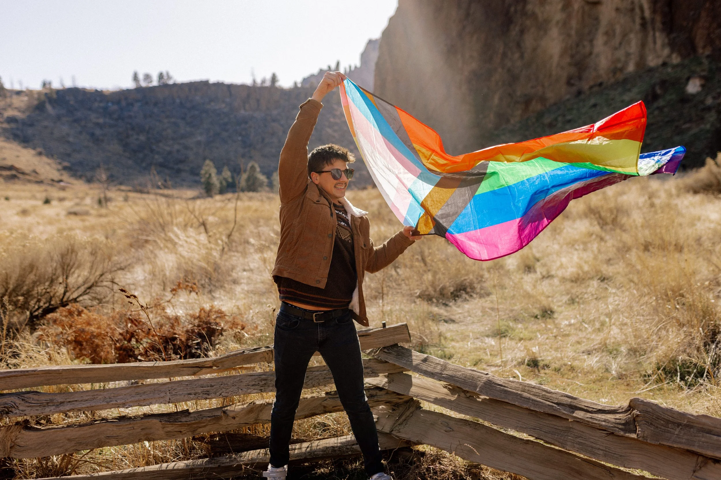 Man holding a rainbow flag in the outdoors