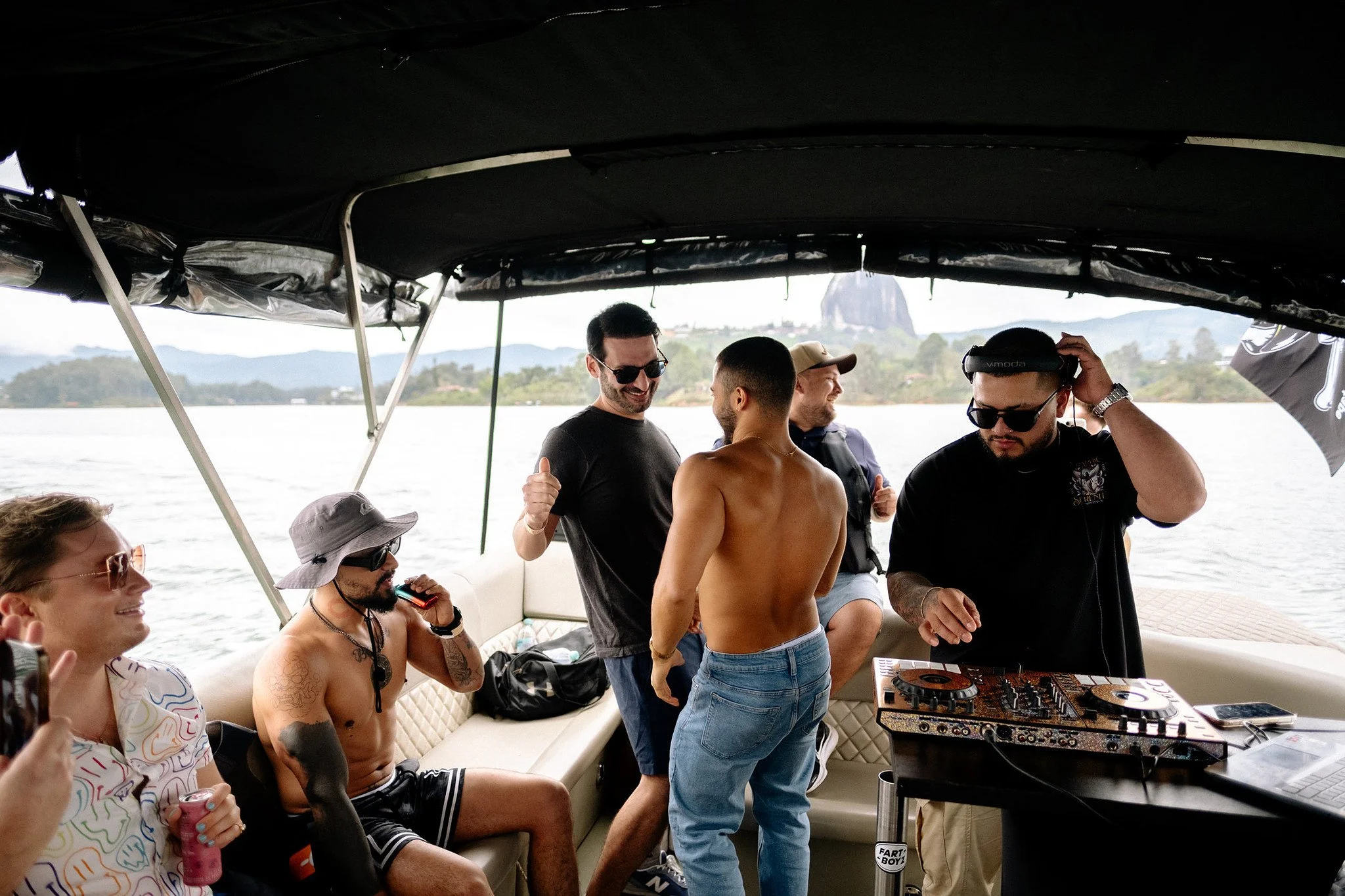 Travelers dancing and DJing aboard a boat on Guatapé Lake Colombia