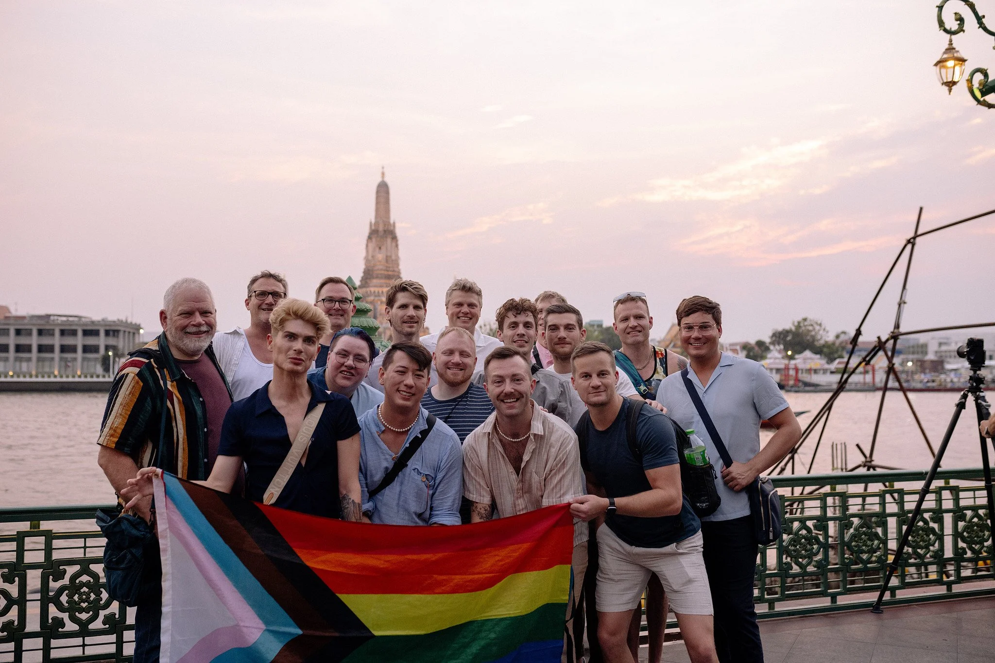  A group holds a Pride flag along the Chao Phraya River as Wat Arun glows at sunset 