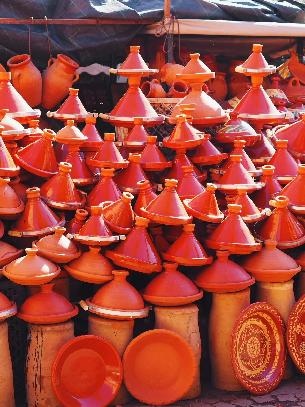  Stacked traditional tagines and pottery in a Marrakech souk stall 