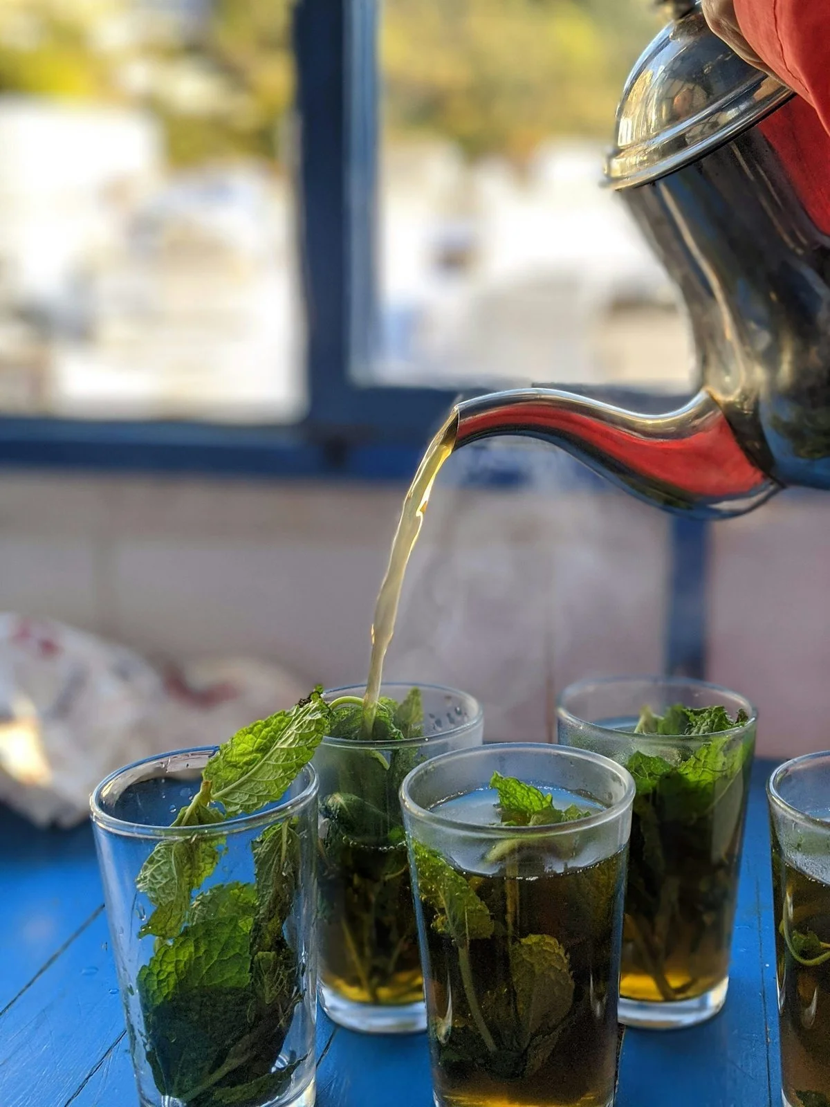 Moroccan mint tea being poured into glasses, a traditional hospitality ritual 