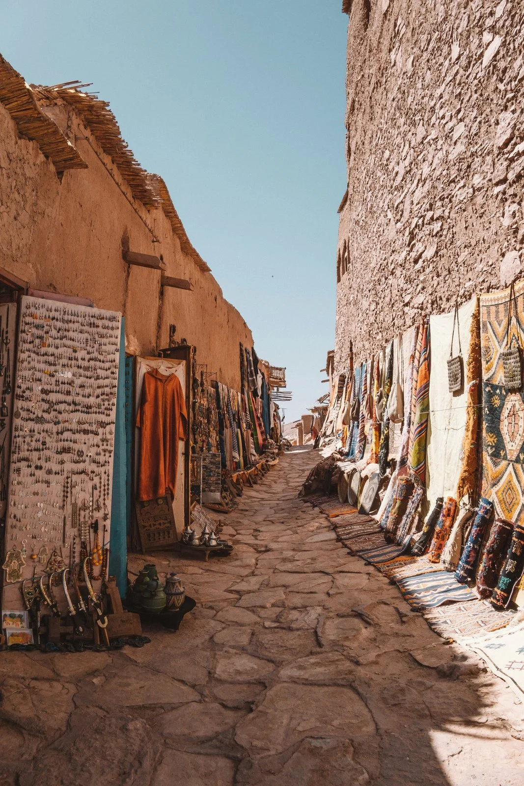  Rugs and jewelry displayed along a narrow alley in Ait Ben Haddou, Morocco 