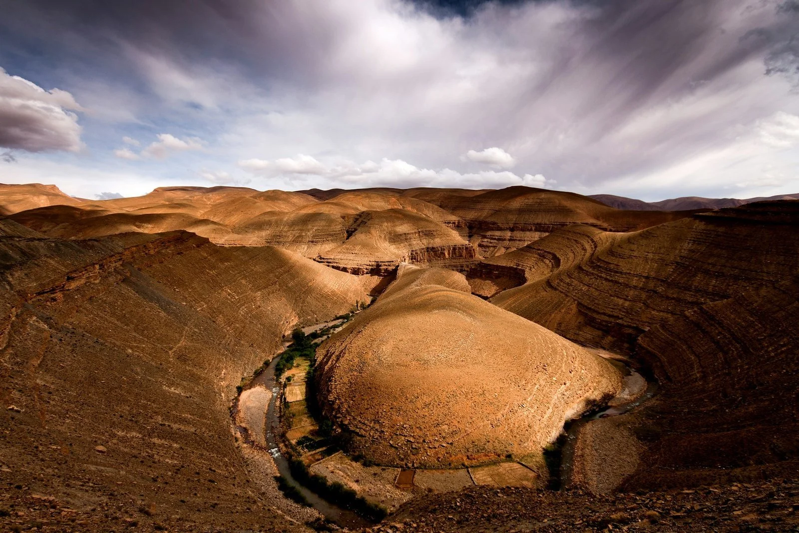  An aerial view of the Dadès Valley's red canyon walls and winding river in Morocco 