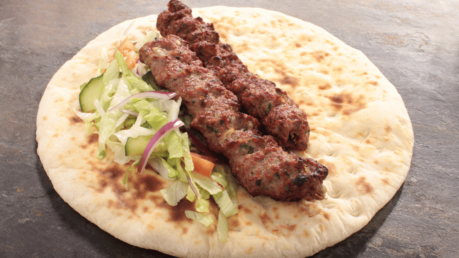 Lamb Qofte on a pita bread with salad