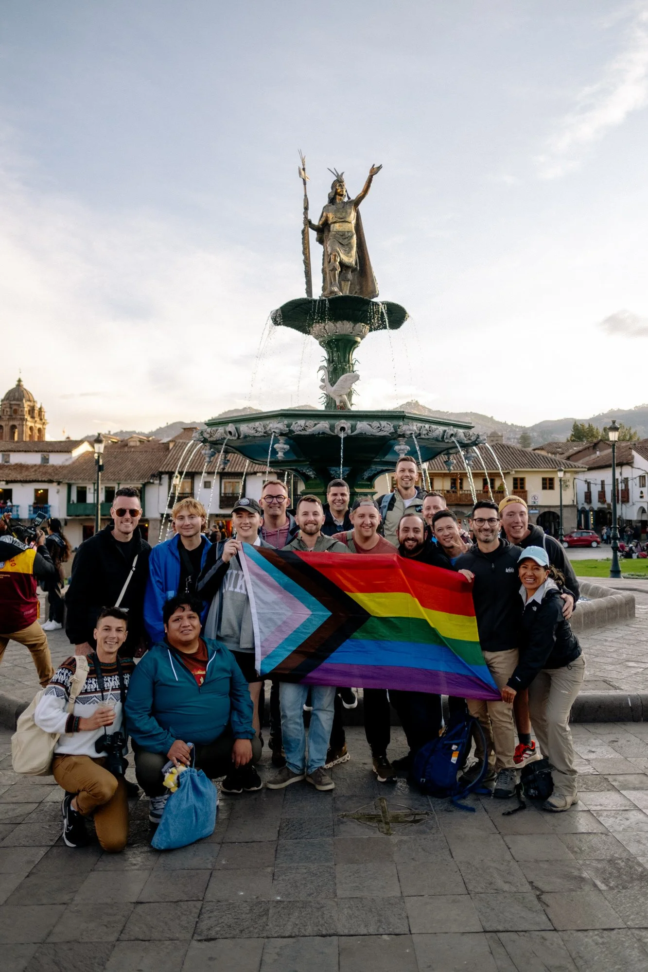 LGBTQ+ people hold a pride flag in the plaza de armas cusco