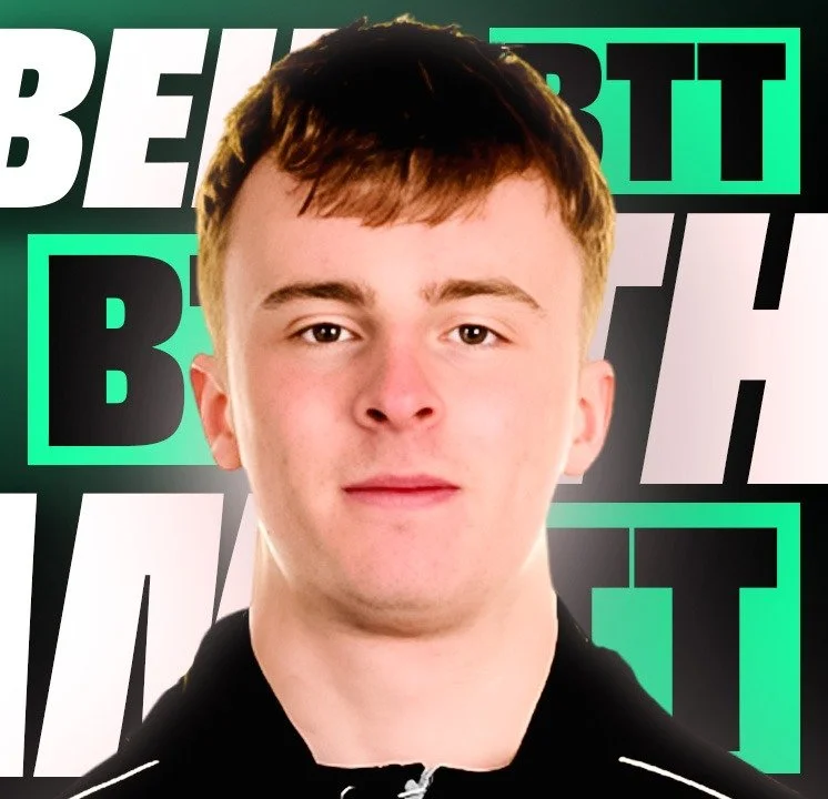 Close-up portrait of a young man with short brown hair, wearing a black jacket, standing in front of a background with bold white, black, and green text.