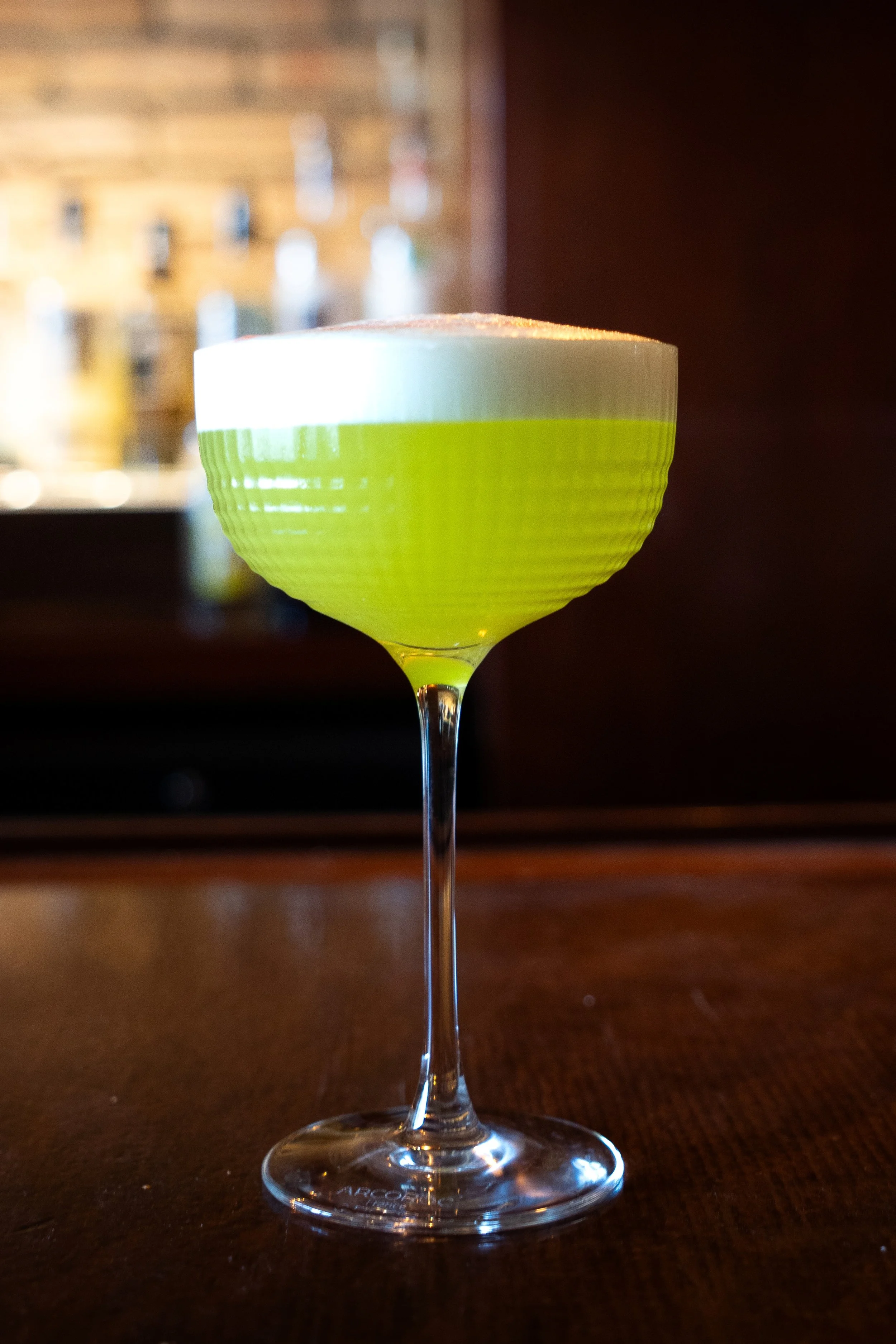 The Midori Pisco Sour at Gunny’s Pub is a bright, playful take on the classic pisco sour, made with pisco, Midori, fresh lime, sugar and egg white for a silky, frothy finish. Vivid green and sharply refreshing, it’s one of the signature cocktails at 