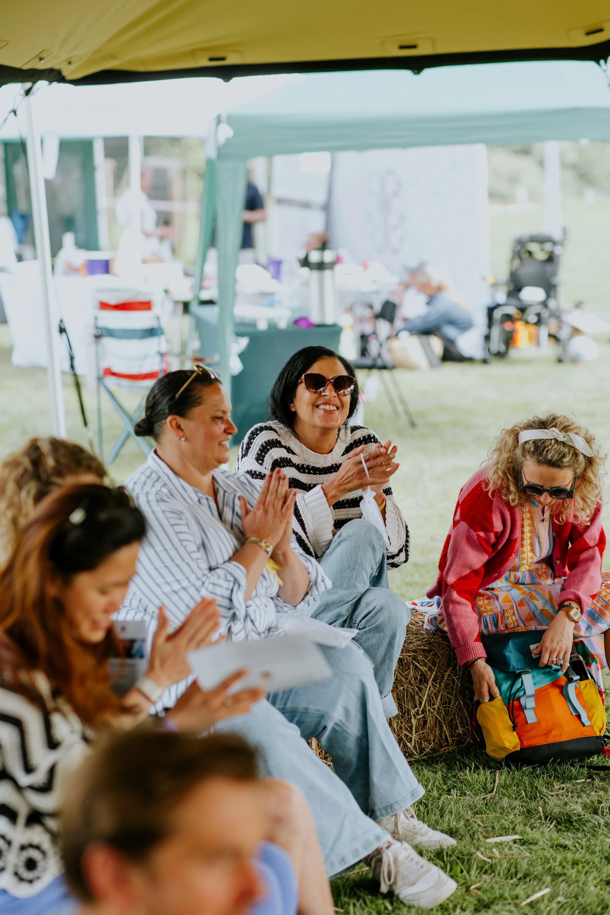 Festival guests sharing a joyful moment outdoors at the sober KamalaFest wellness festival in Wokingham.