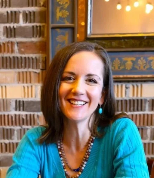 A women wearing a blue shirt and smiling