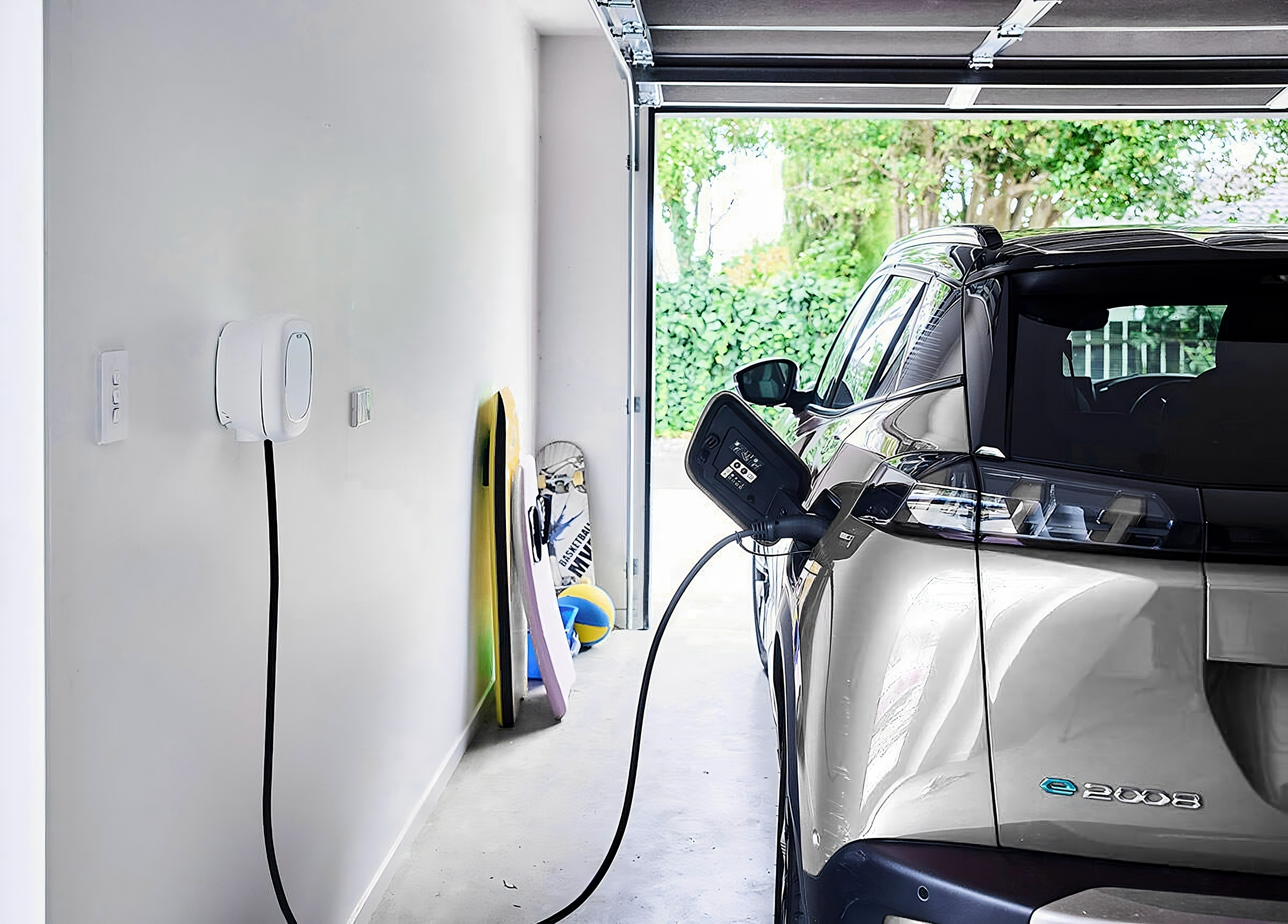 Electric car plugged into a wall charger inside a garage as an example of the benefits of having solar system and controlling your own power generation.