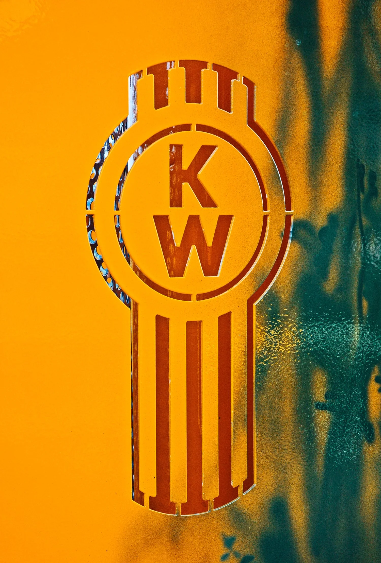 A kenworth logo cut into the headboard of a flat deck on a truck