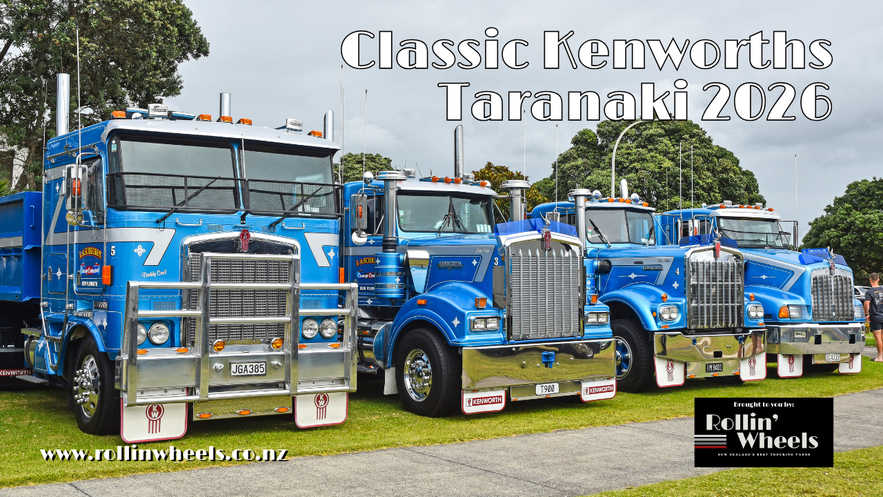Four blue trucks parked on grass