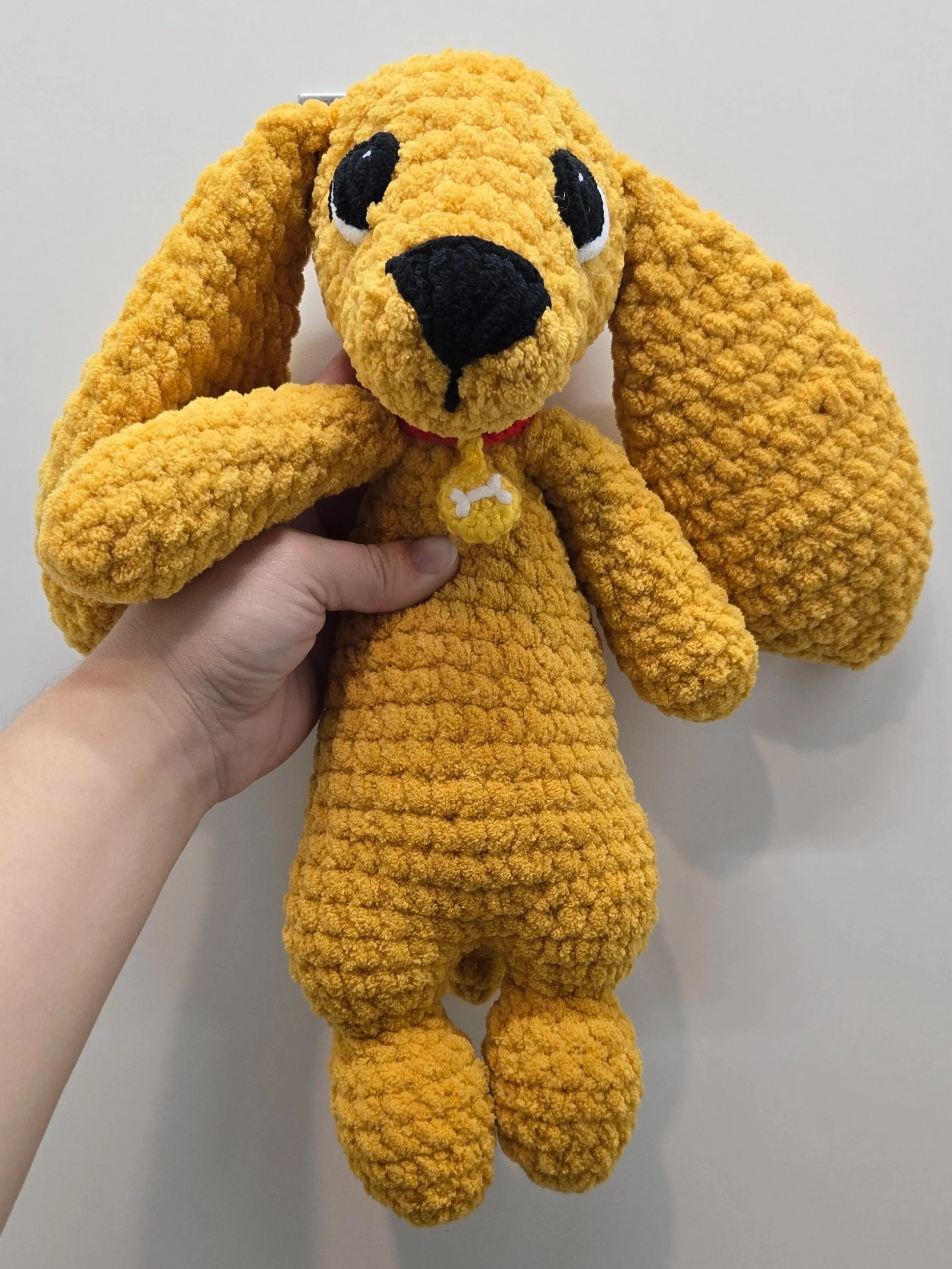 Charlie the dog Snuggler crochet pattern; modified to add crocheted eyes and a dog bone collar.