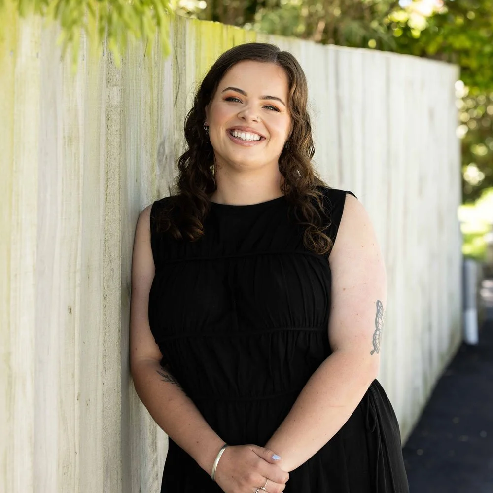 Alex leaning on fence smiling