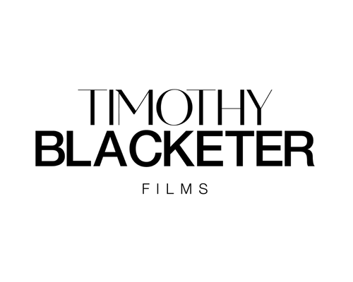 Black silhouette of a deer standing on the ground with antlers, against a plain white background.