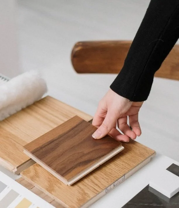 Sample selection of wood flooring options with various textures and shades, accompanied by a label indicating a free design guide.