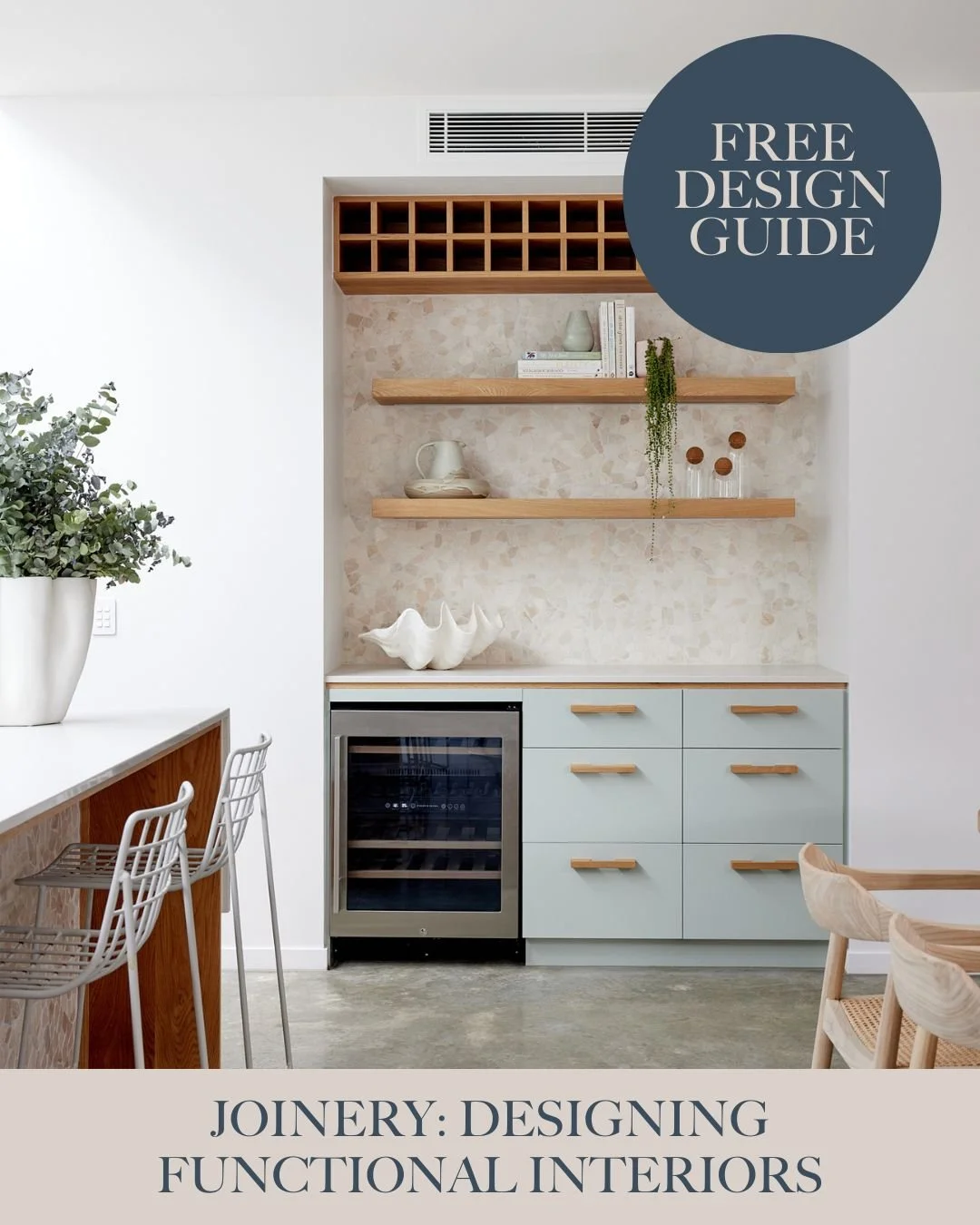 Decorative kitchen with light blue cabinets, open wooden shelves, a wine cooler, and minimalist white and beige decor.