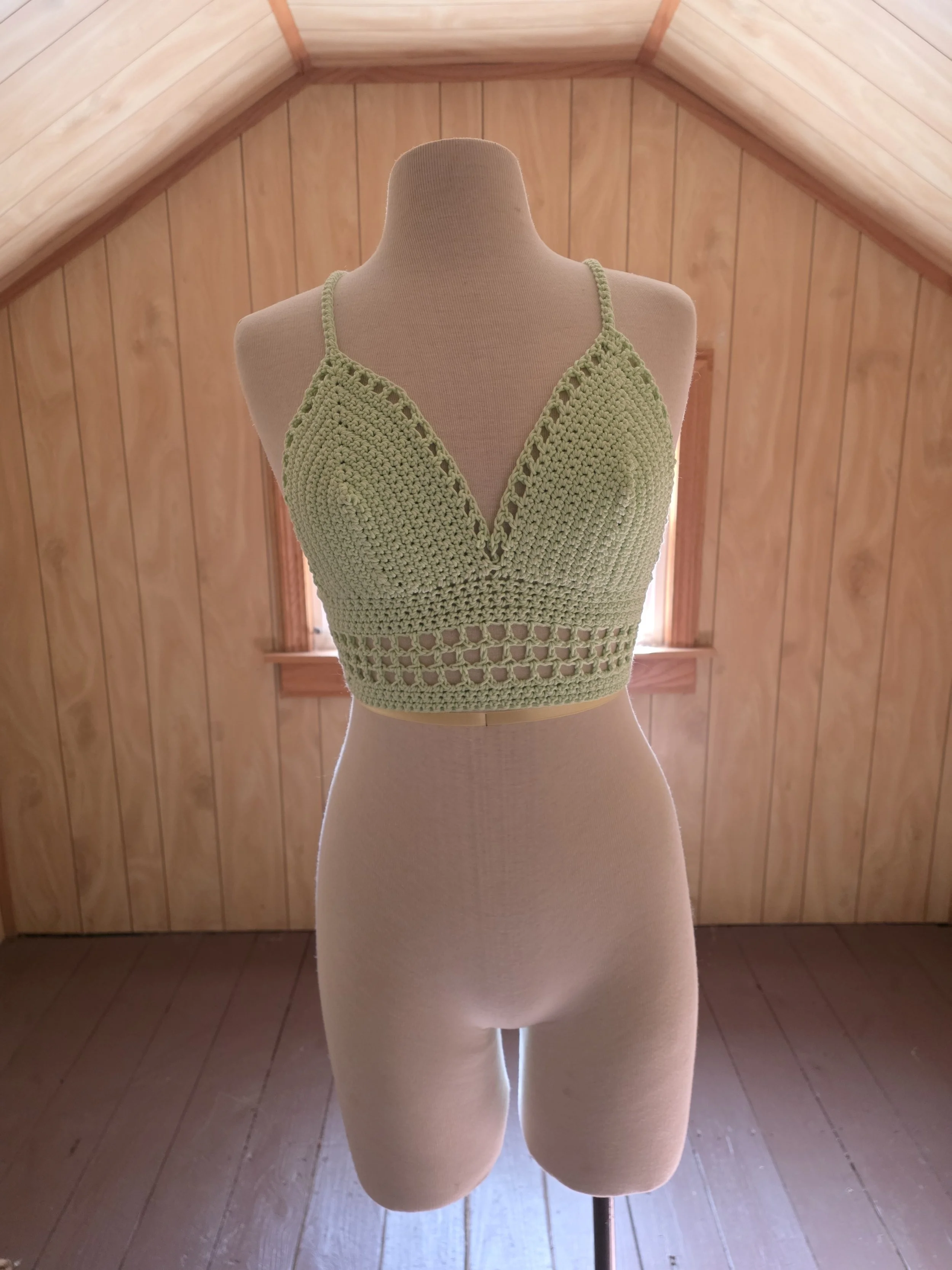 Handmade crochet glow-in-the-dark bralette in size medium on dress form