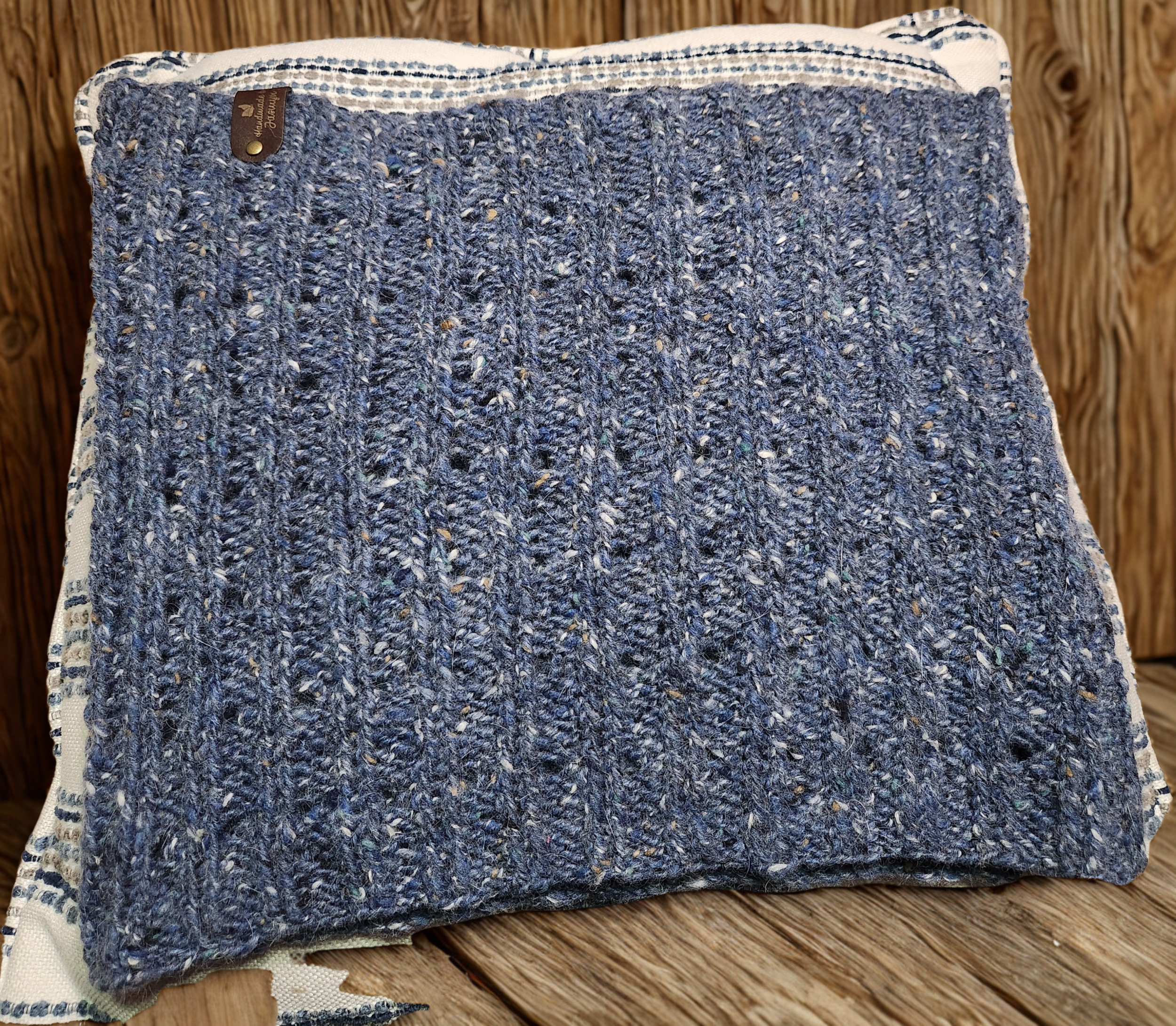 Handmade knitted cowl in blue, flat lay view showing stitch pattern