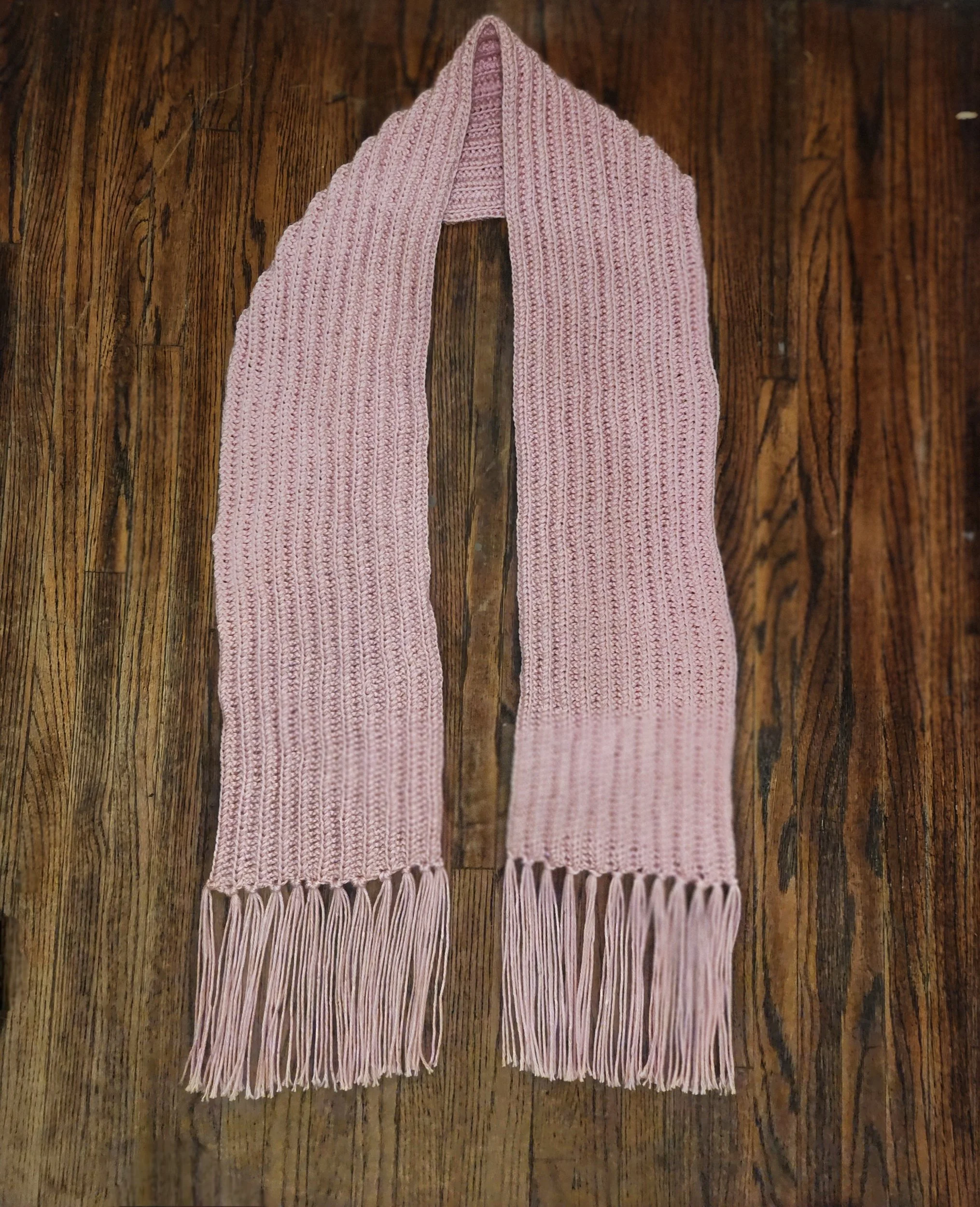 Handmade custom lacy scarf in pink, flat lay with tassels