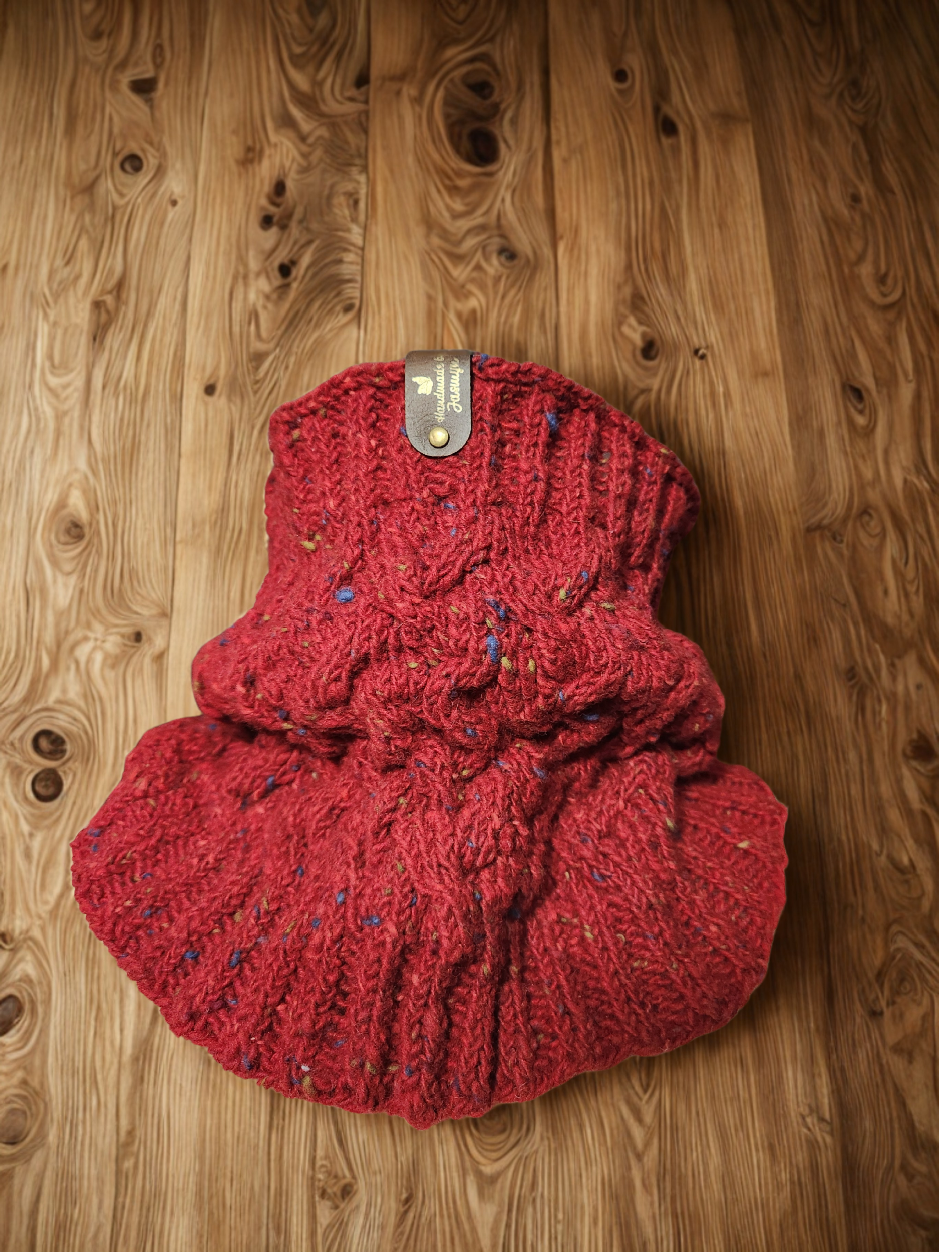 Handmade knitted cabled cowl in red, scrunched to show cable pattern