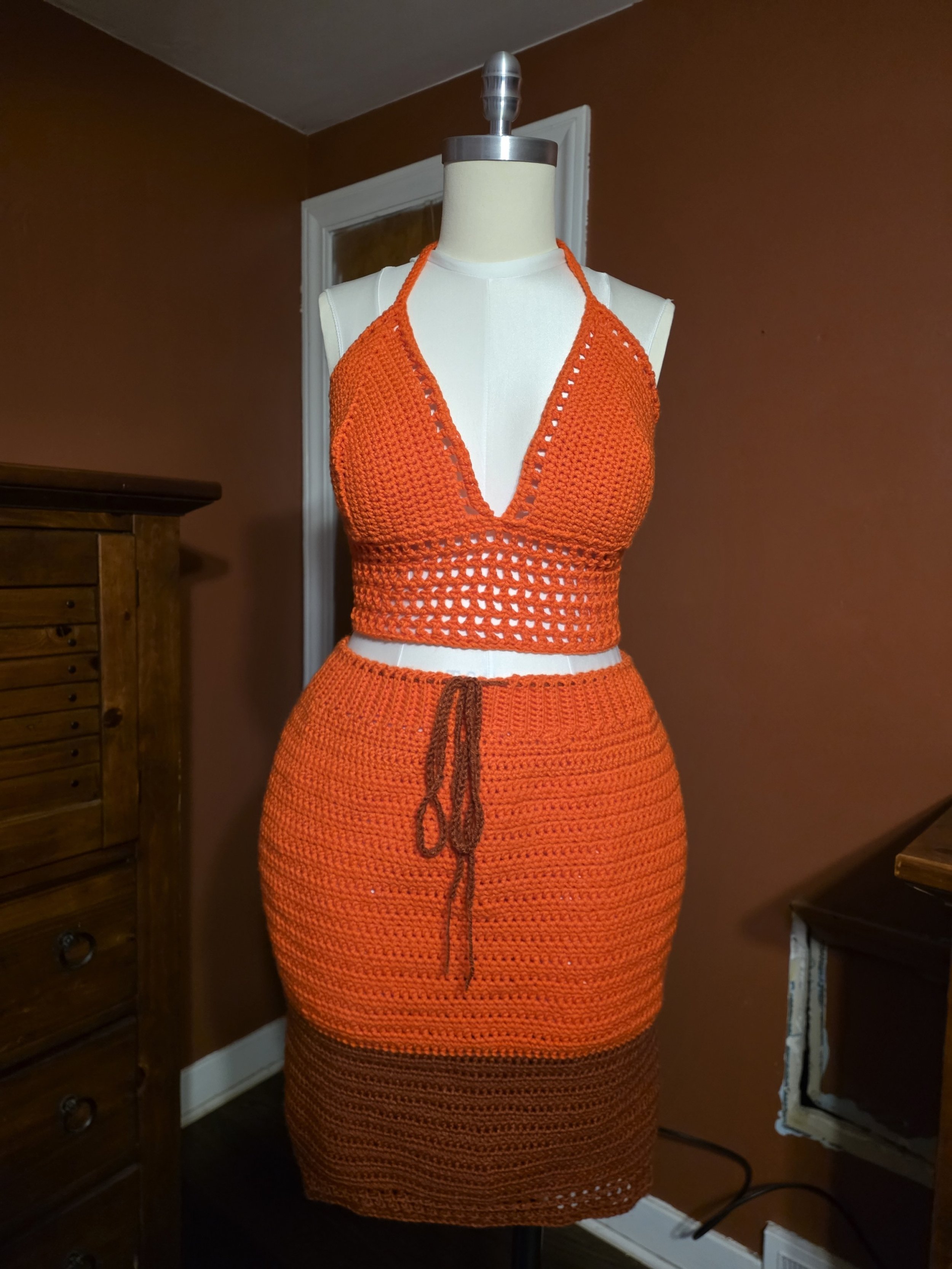 Handmade crochet mesh top and fitted skirt in orange on dress form
