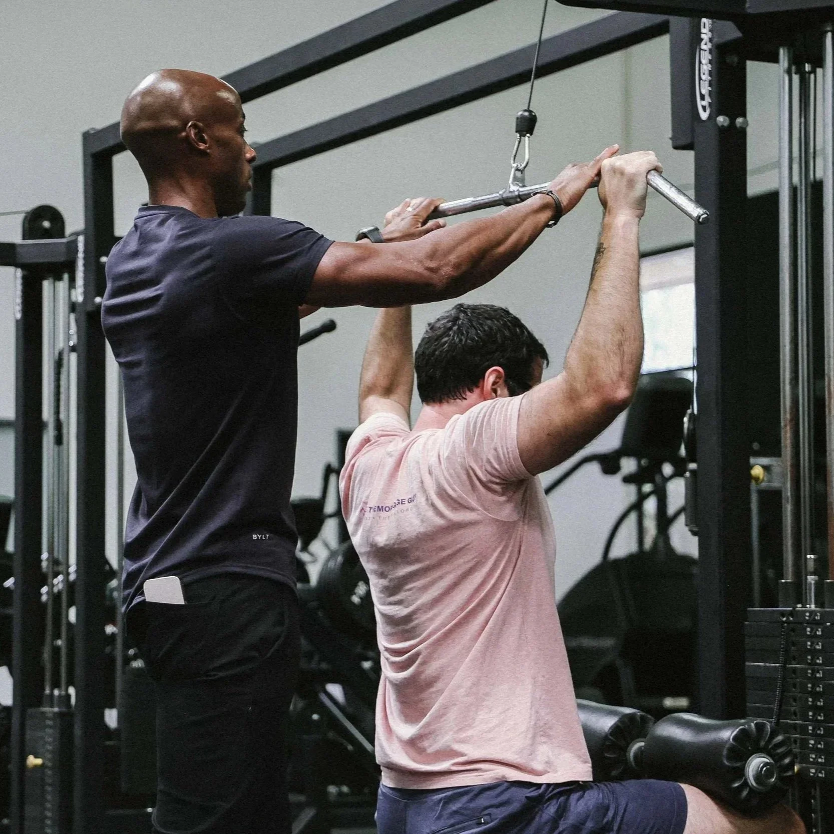 Akram Hameed coaches a client during a strength training session at the gym.