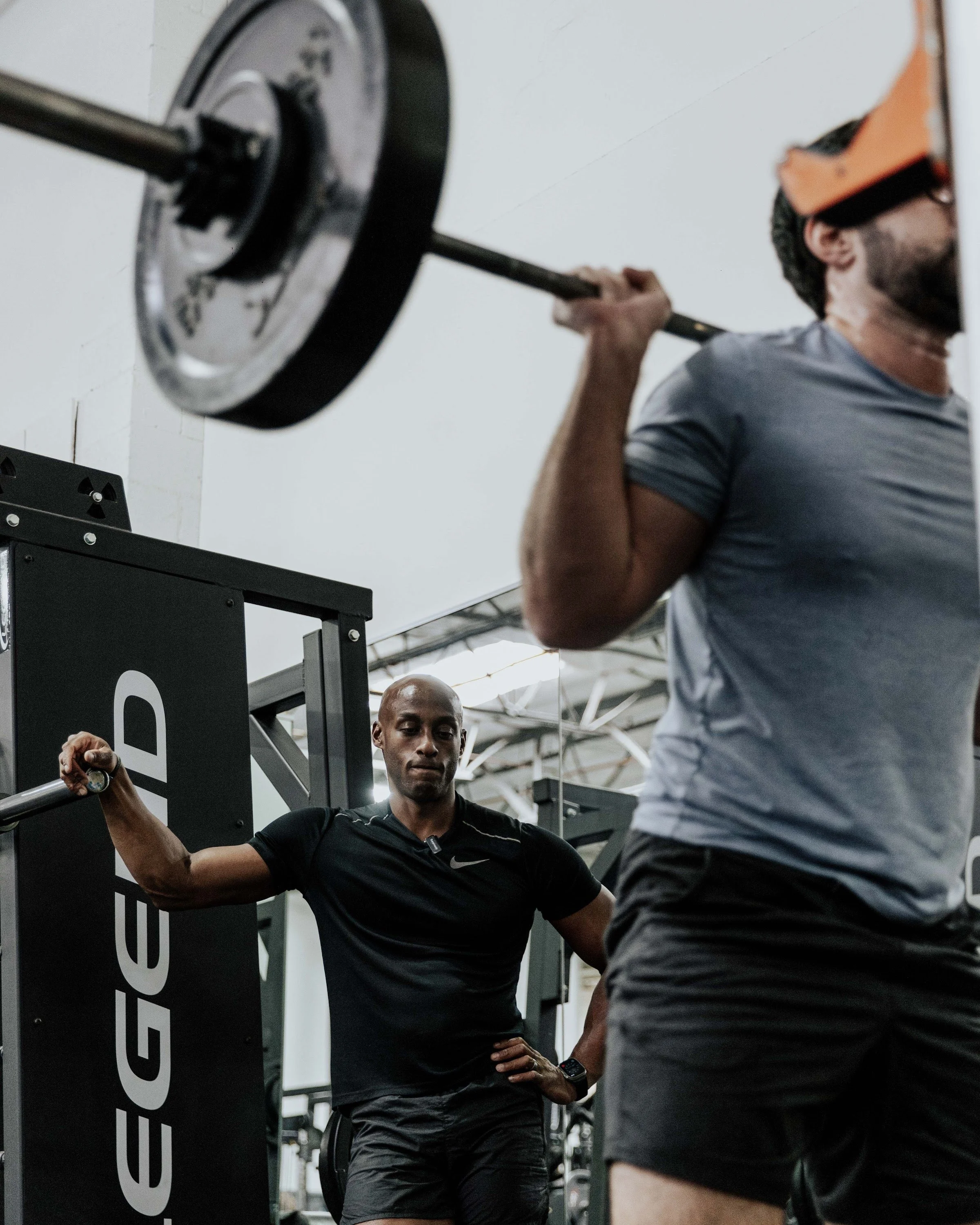 Akram Hameed spotting a client through a barbell squat