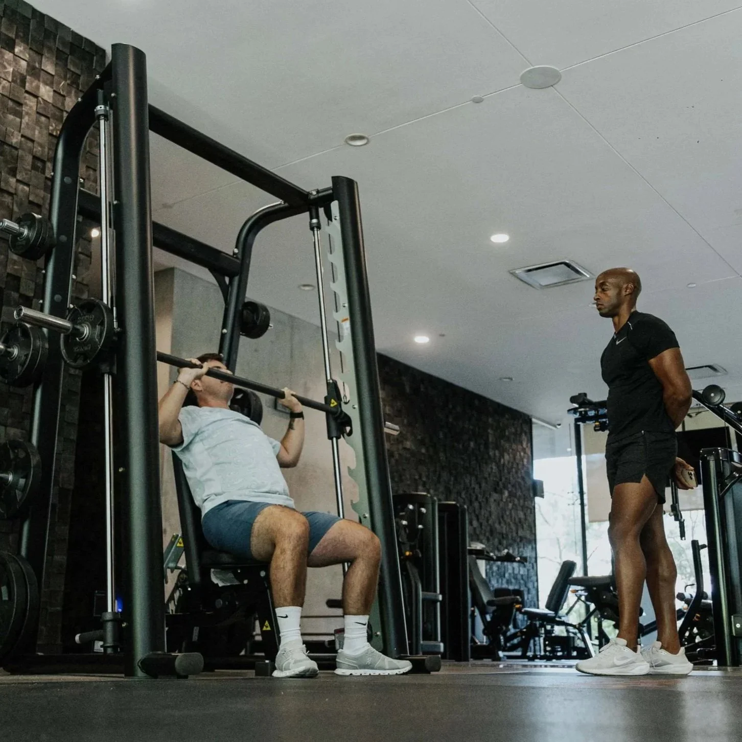 Client seated between strength sets on a gym machine.