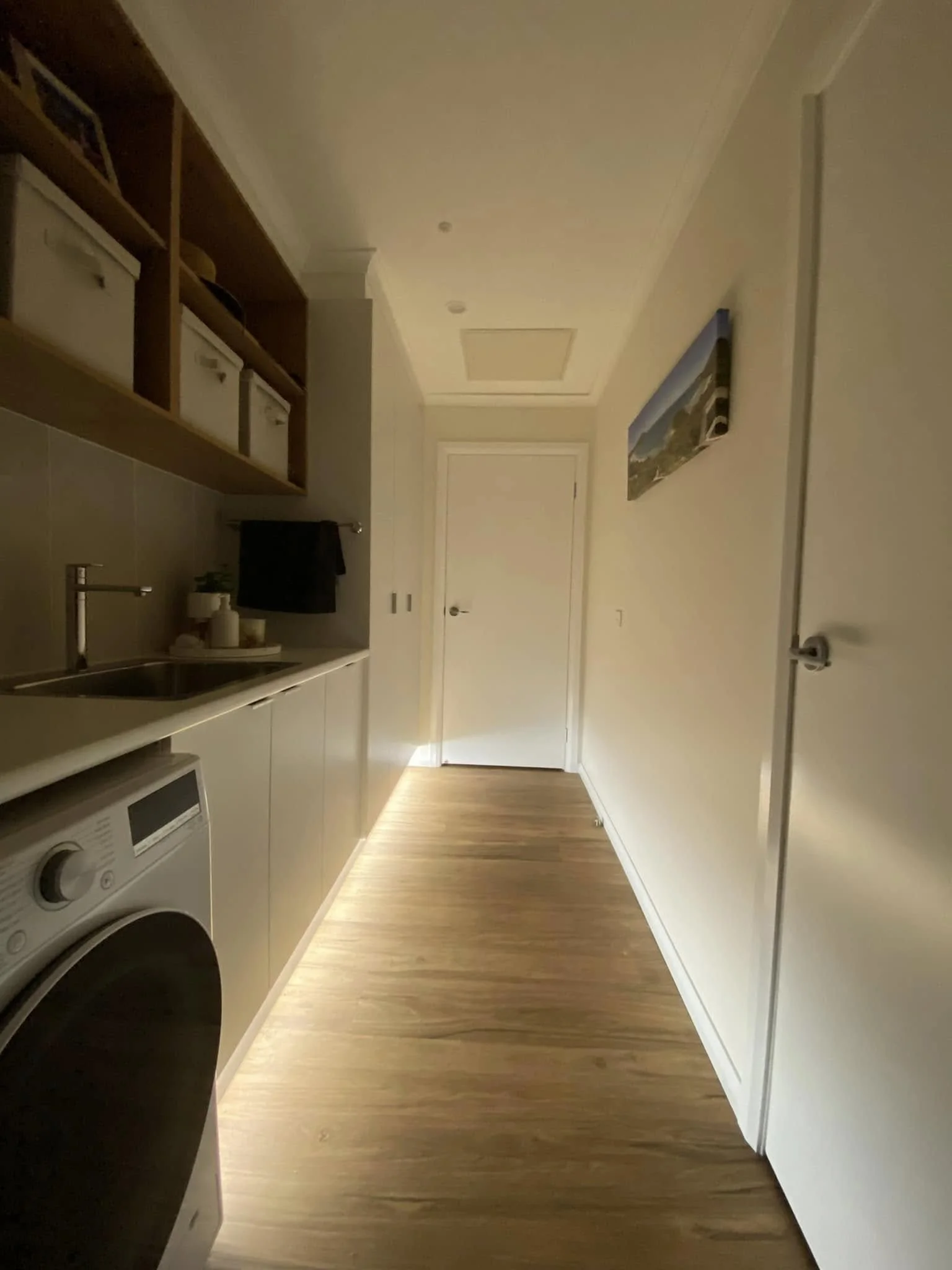 Lighting design in a white laundry room shoing the hallway