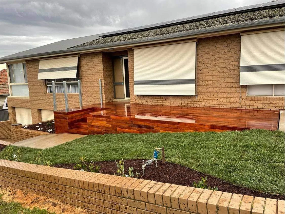 A new deck with steps in front of a brick building.