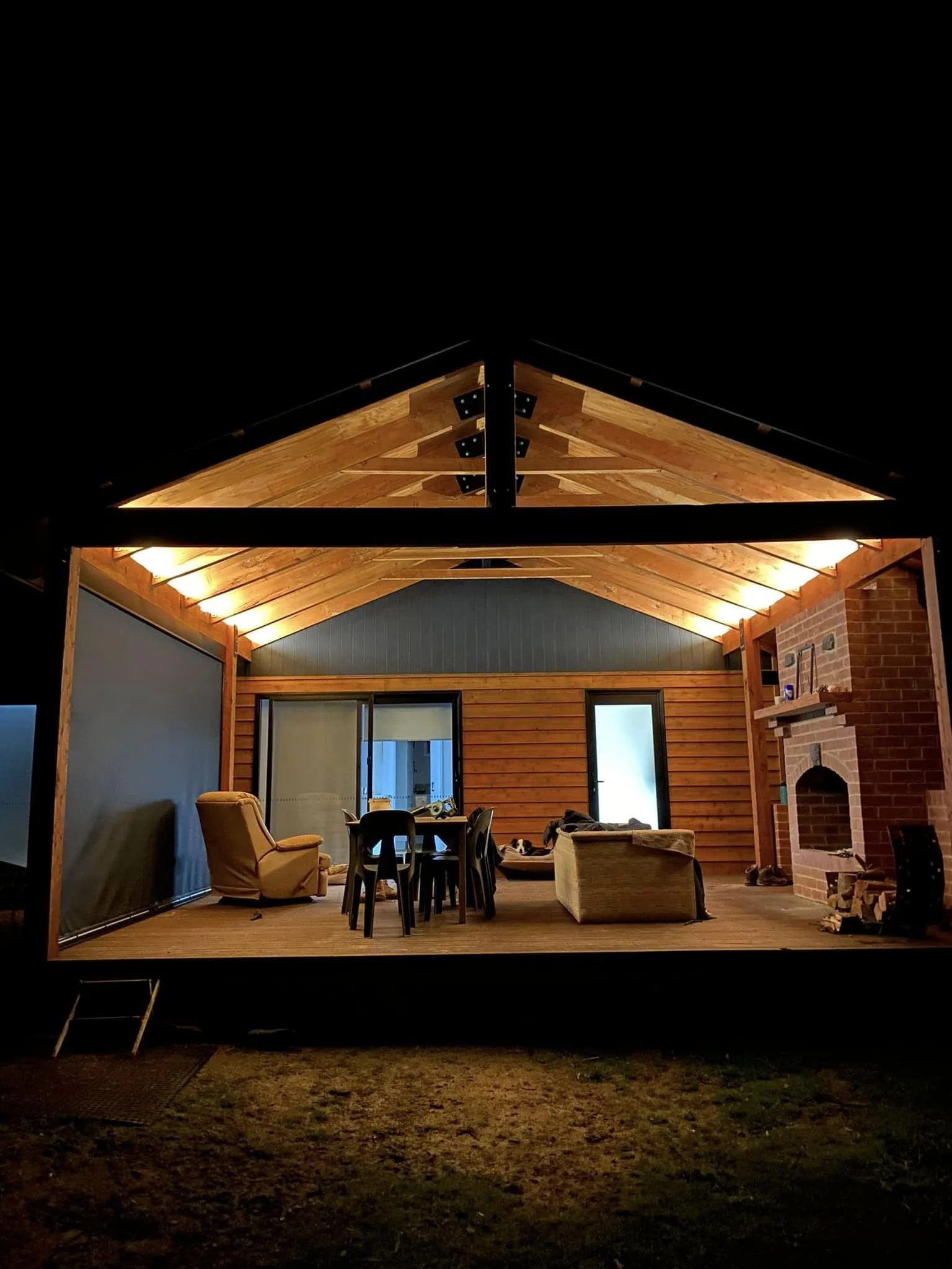 Warm under-roof lighting on a wooden deck at night