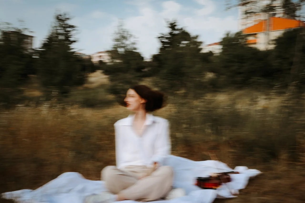 Portrait d'une femme flou assise sur une couverture dans une clairière 