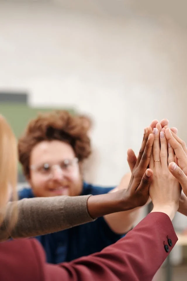 Groupe de personnes qui se congratulent en joignant leur mains