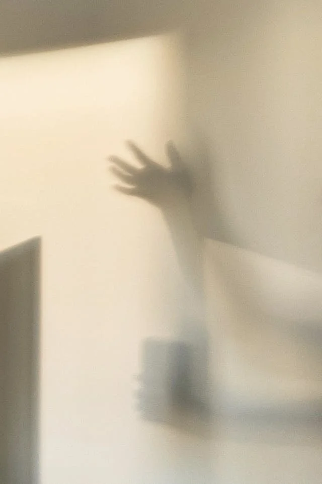 Ombre chinoise d'une main sur un mur beige