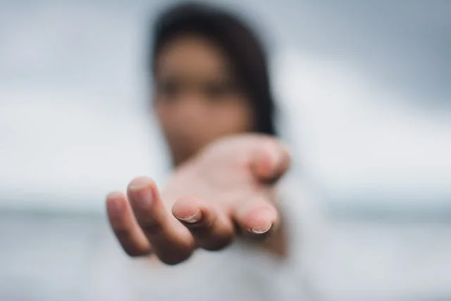 Portait d'une femme floue avec une main tendue vers l'objectif