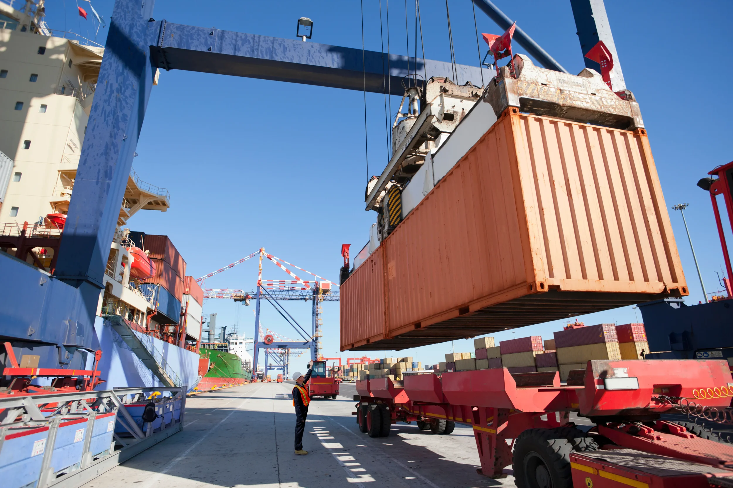 Overview of a space where a container is being placed on a trailer, simulating a supply chain.