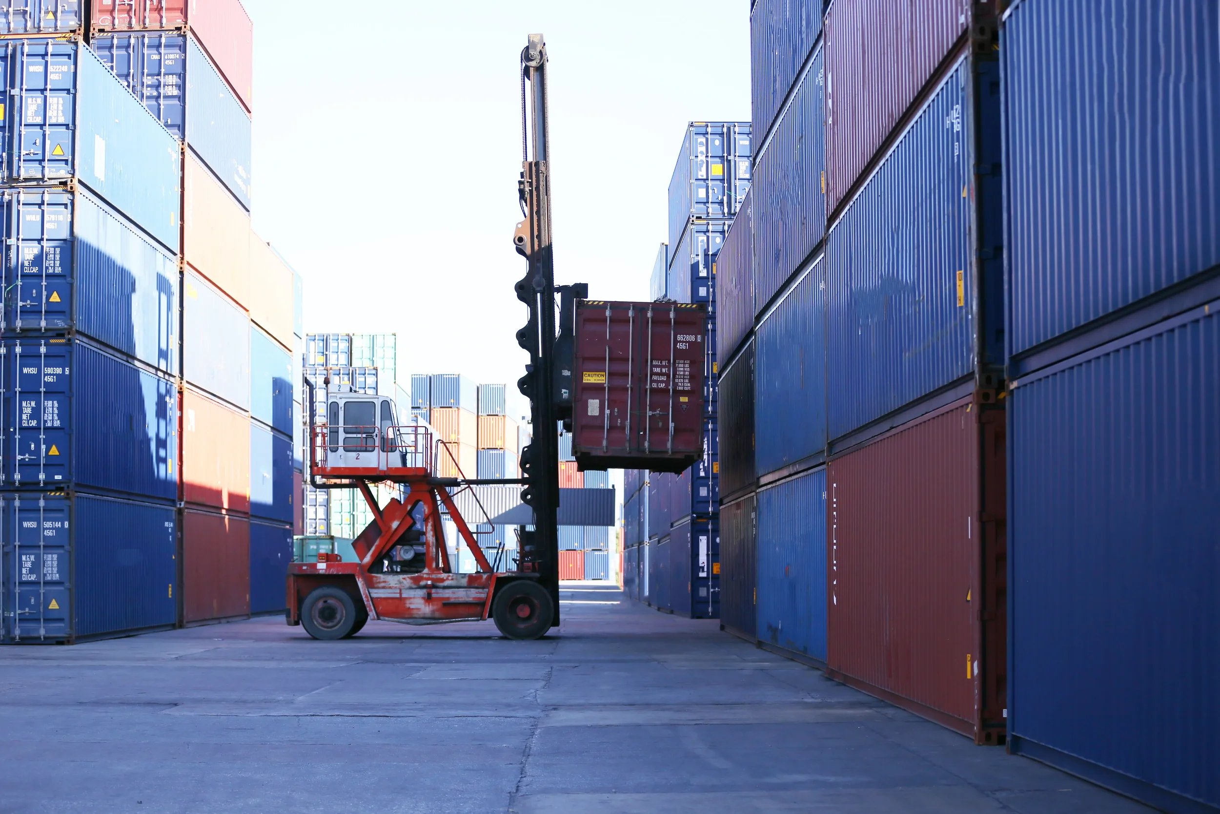 General view of a yard where a vehicle is loading a container for assembly.