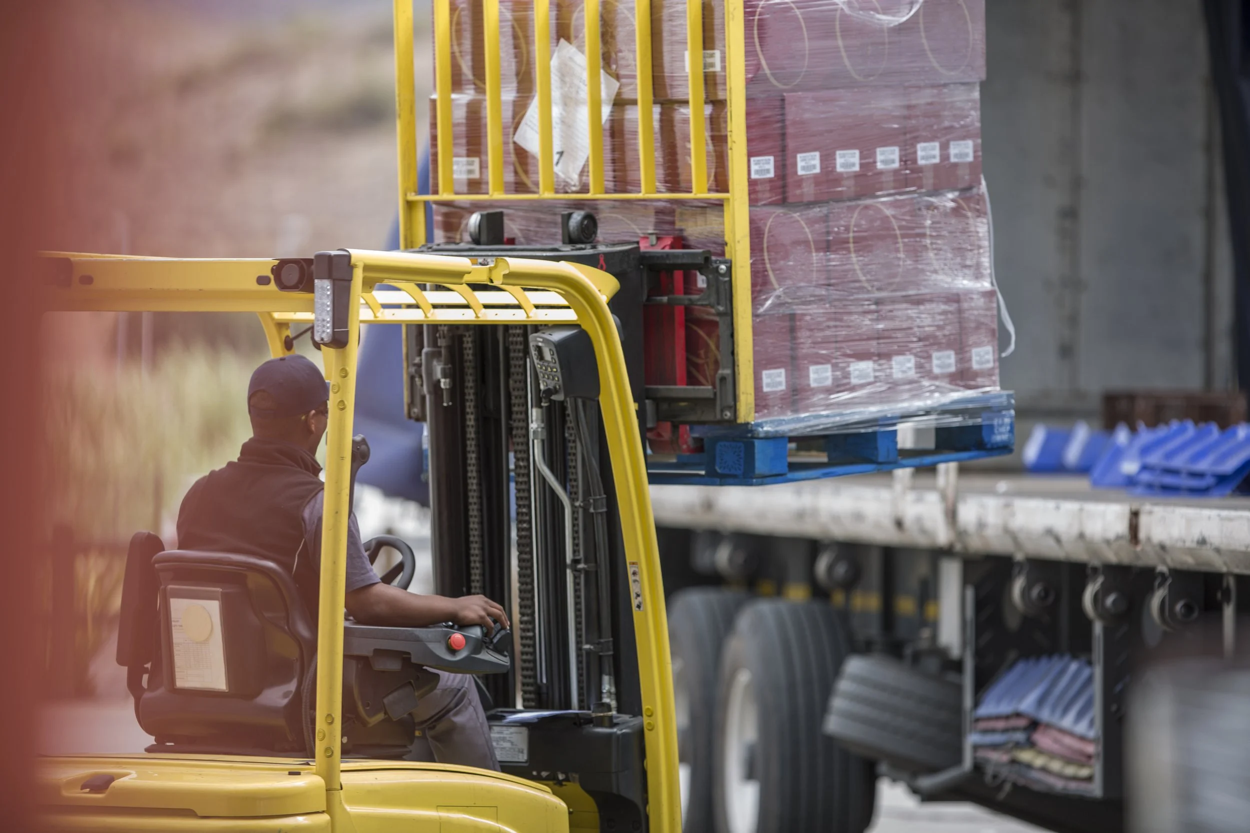 Vista general de una grua con un cargamento para ingresarlo a un trailer.
