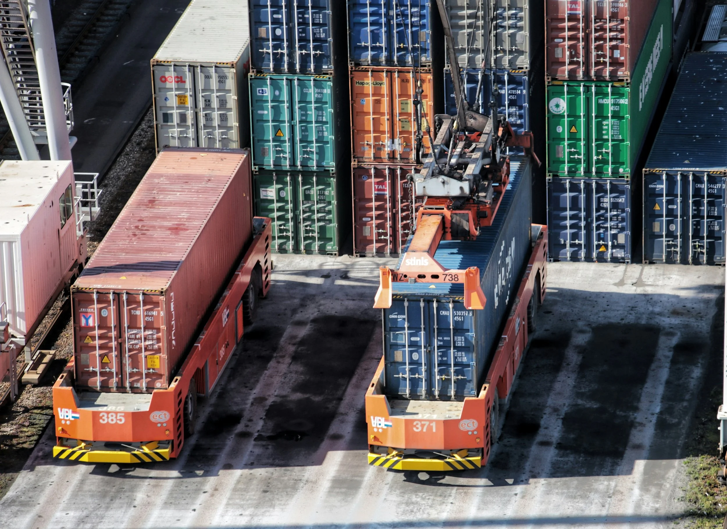 High-angle view of two transport vehicles being loaded at the logistics center.