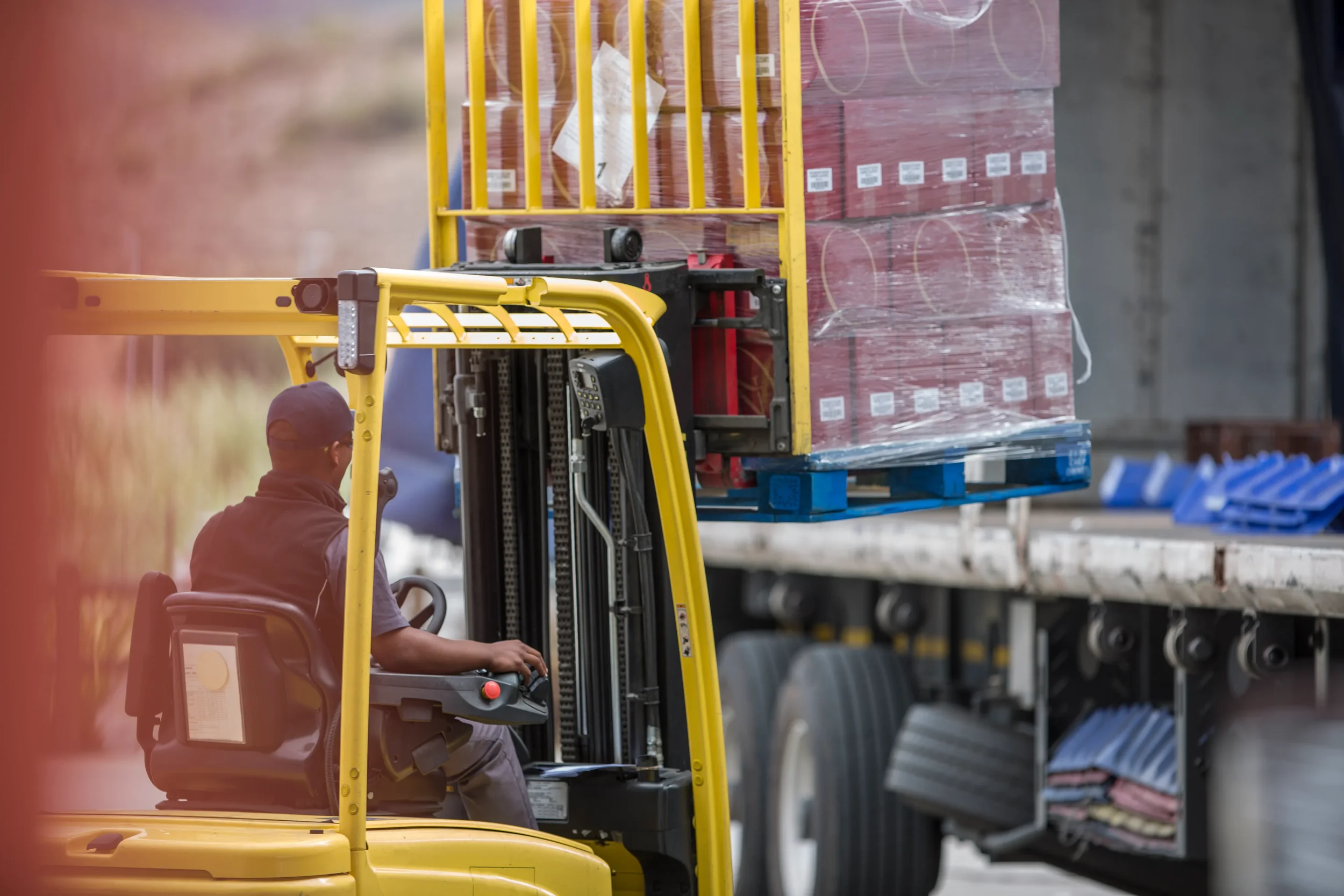 General view of a crane with a load being loaded onto a trailer.